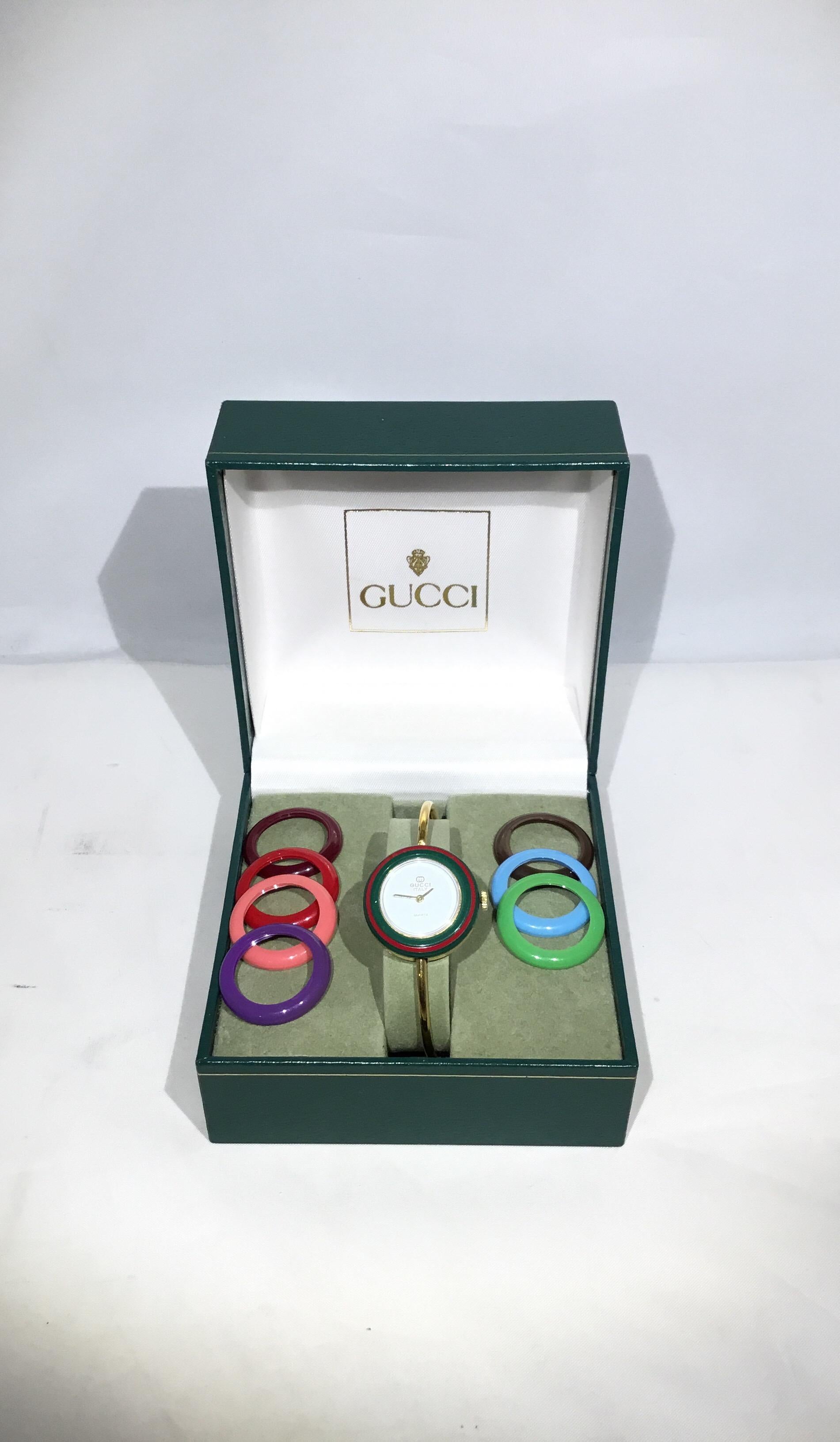 Vintage Gucci watch features a gold tone metal band with 8 interchangeable bezels. Battery needs replacement. Excellent condition.

6.5 circumference. 2.25” opening