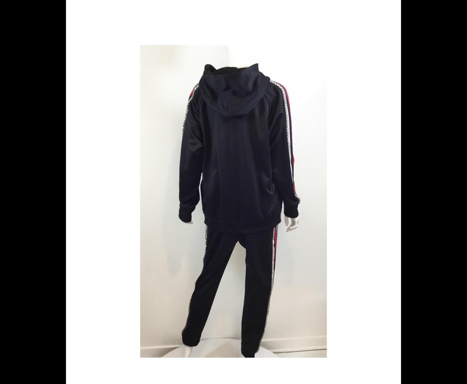 Gucci tracksuit Jacket featured in a black tech-jersey fabric with a red and navy web panel along the sides encrusted with Swarovski crystals. Jacket is hooded and has a zippered fastening. Track suit jacket is brand new with tags, size XL, Made in