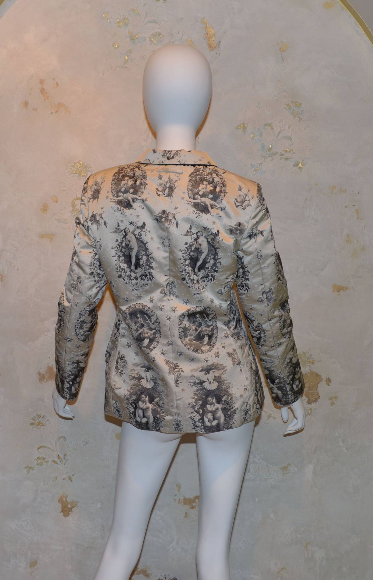 Jean Paul Gaultier blazer features a 'cherub' print throughout with concealed button closures along the front, and a fun sequin detailing under the collar as pictured. Blazer includes 2 slip pockets near the hem and one pocket at the left bust. Made