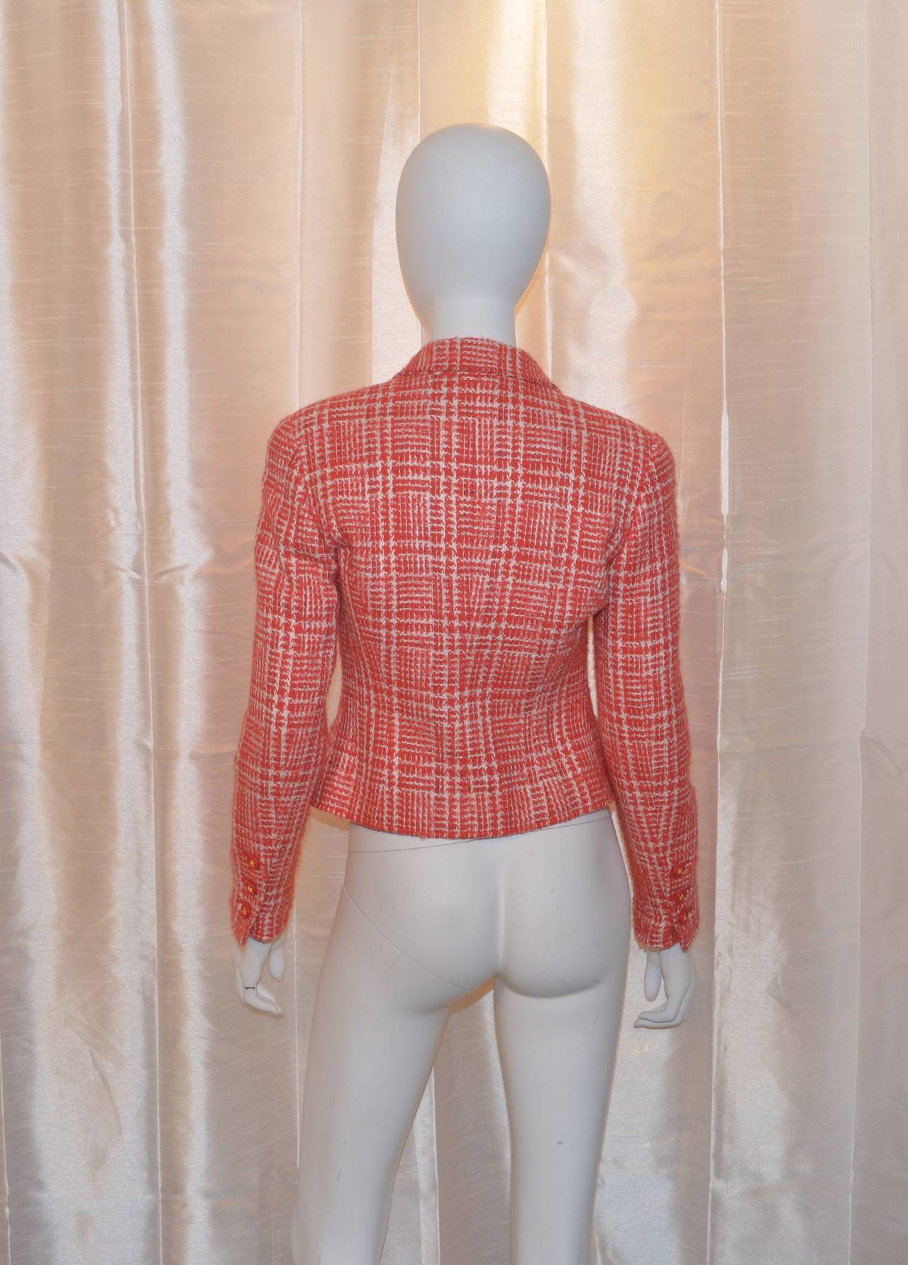 Chanel blazer has three red and gold-tone button closures along the front center and on the cuffs, two small slip pockets at the hem, and fully lined. Made in France and marked a size 38. 47% wool, 44% acrylic, 4% rayon, 3% mohair, and 2% nylon.
