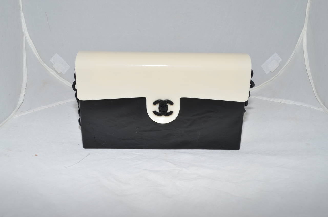 Chanel lucite bag features a color block detail, flap opening with a decorative CC clasp closure, full fabric lining with one zipper pocket and one slip pocket. Dust-bag included. Made in Italy. Circa 2000-2002.

Dimensions:
8.75'' x 2'' x