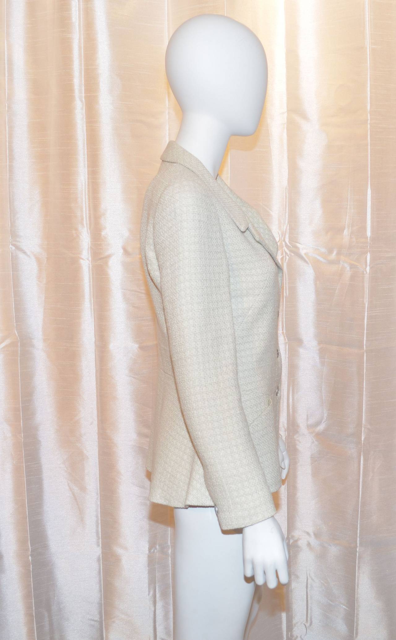 Chanel blazer has silver-tone cutout button closures along the front center as well as on the cuffs, two slip pockets at the side hem, and a chain trim in the hem. Made in France, size 40. 80% wool, 20% rayon. Lining: 90% silk and 10%