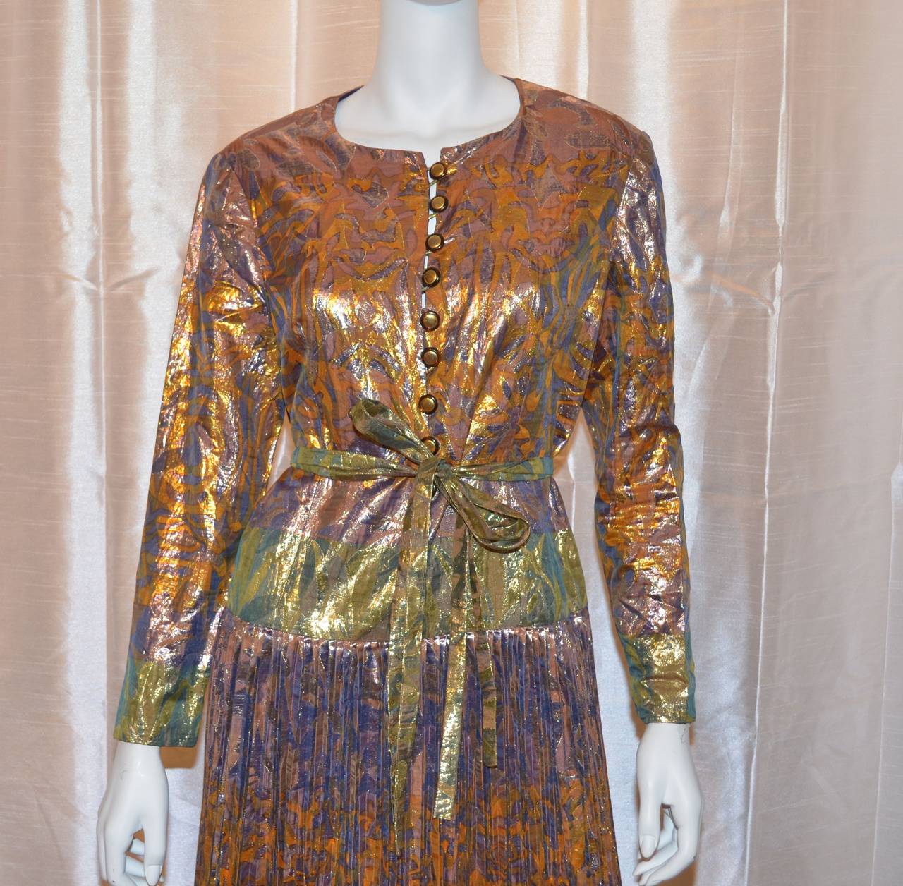 Vintage Lanvin dress features a metallic multicolored print, on lightweight lame fabric, button closures along the front center of the bodice, waist tie closure, and a pleated skirt. Made in France.

Measurements:
Bust - 39''
Waist - 34''
Hips