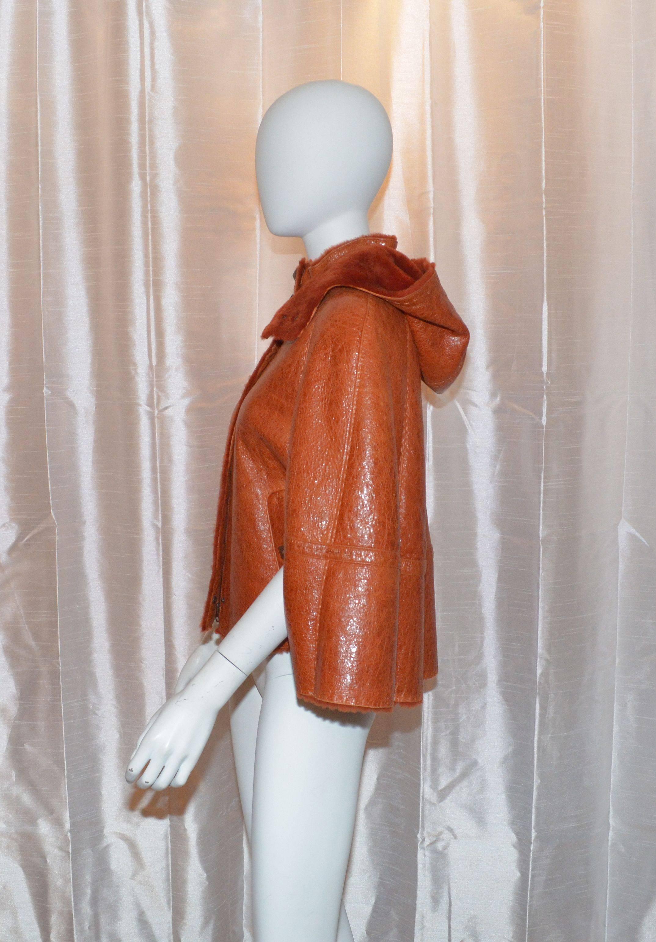 Escada Sport Burnt Orange Lambskin Leather Shearling Fur Poncho Cape w/ Hood

Escada cape features a full zipper closure along the front center, snap stud closures at the neck, arm hole inserts, and two pockets also with snap stud closures. Hood