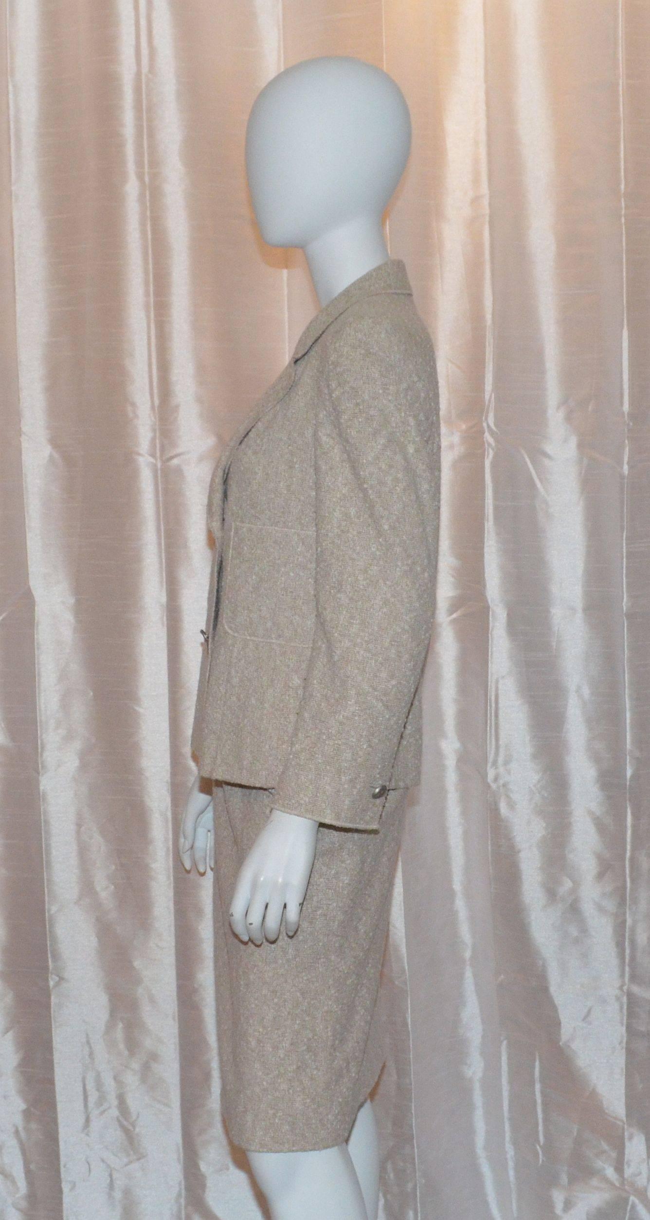 Classic Chanel suit jacket has silver-tone button closures at the front, two slip pockets at the bust, and jacket is fully lined. 54% cotton, 42% wool, 4% nylon, and lined in 100% silk. Skirt features a side zipper and hook-and-eye closure.