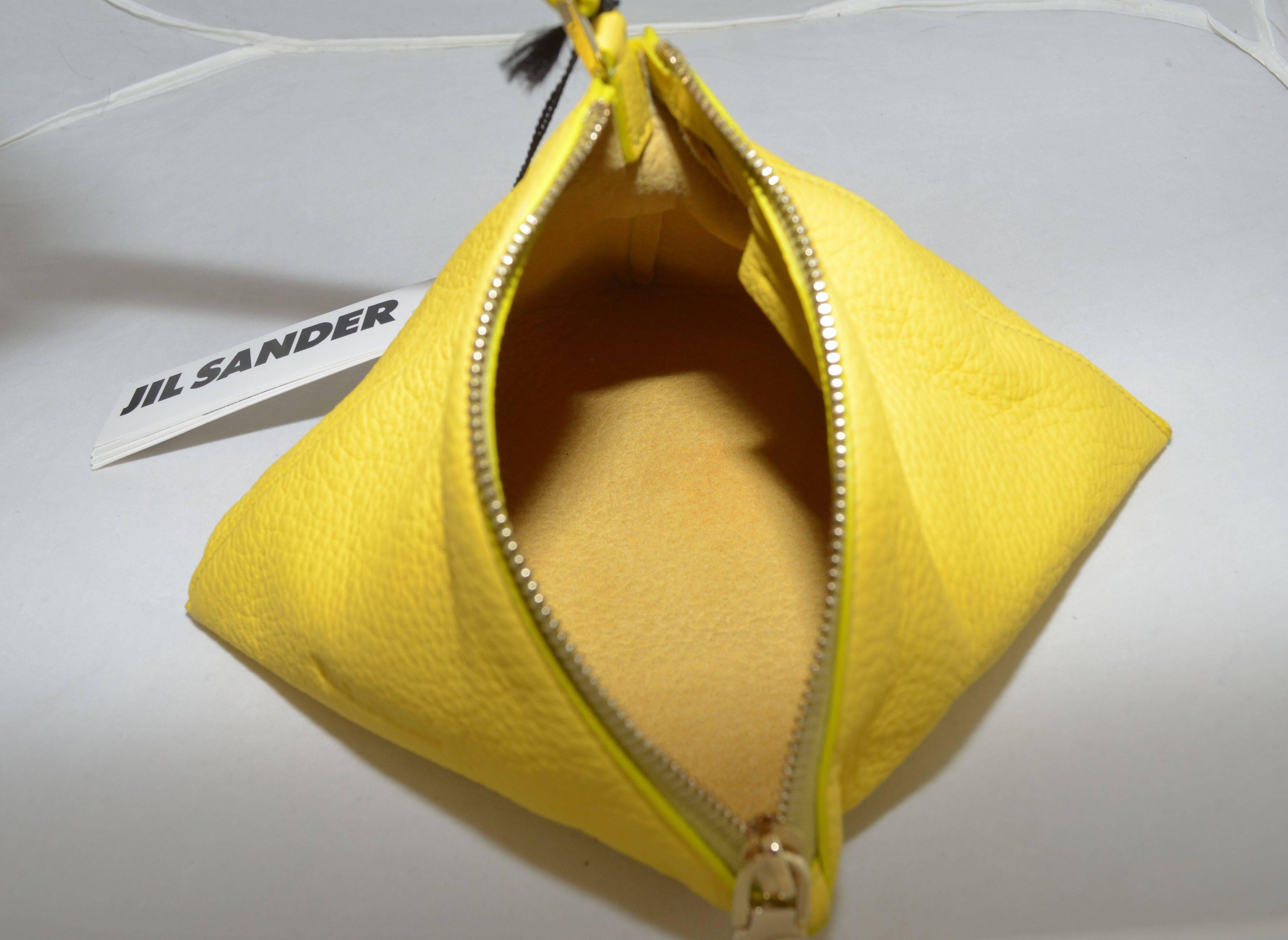 Jil Sander Leather Pyramid Wristlet Clutch Bag is made with genuine leather, gold-tone hardware throughout with a zipper closure, and a flat leather handle. Includes original dust bag. Made in Italy.

Measurements: 
7''x 7'' x 7.5''