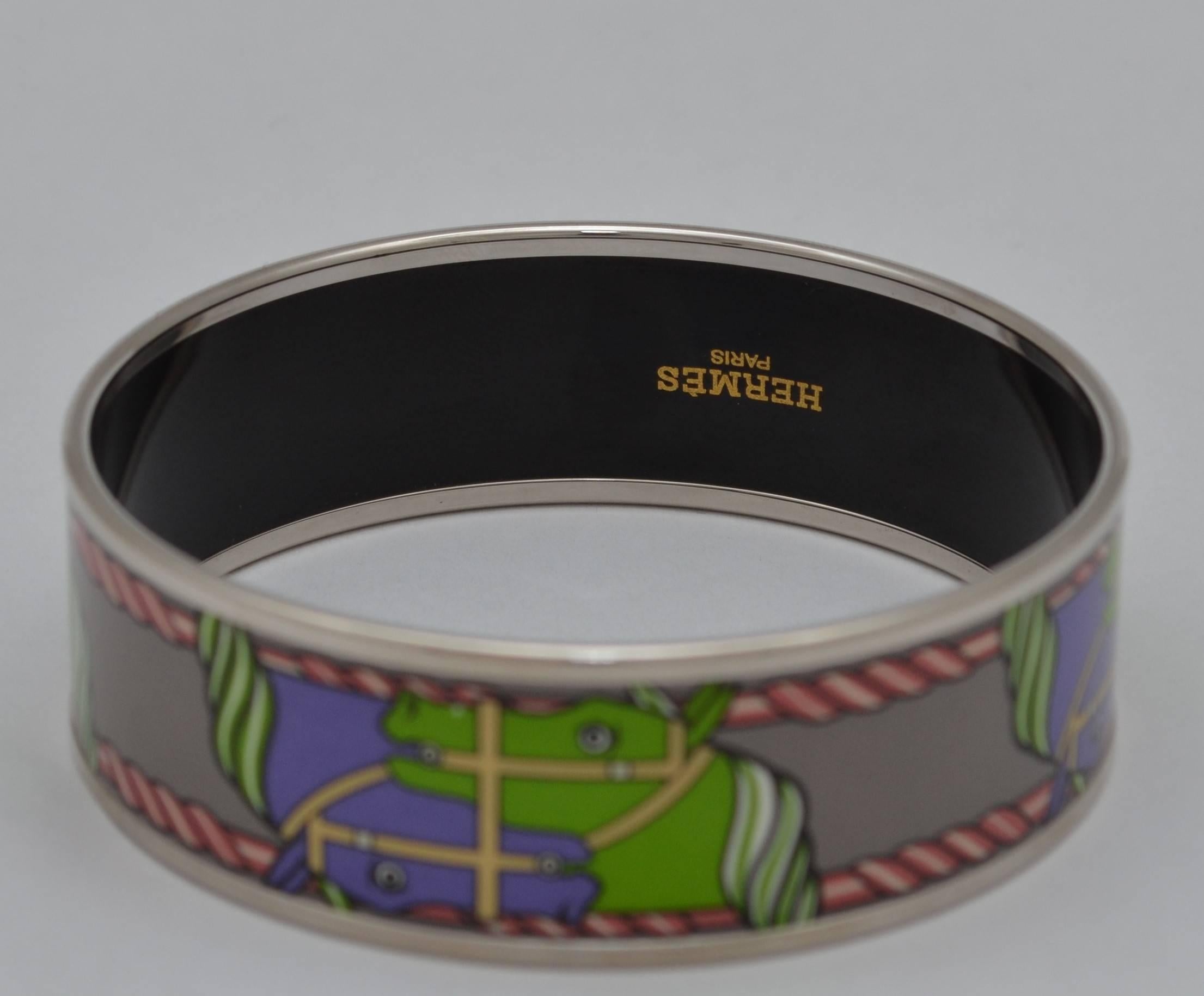 Hermes Paris Palladium Silver Multicolor Equestrian Horse Print Enamel Bangle Bracelet Small Size 62

Hermes Paris bangle featured in a silver-tone metal and an equestrian print throughout with purple, green, pink, and grey tones. Made in France.