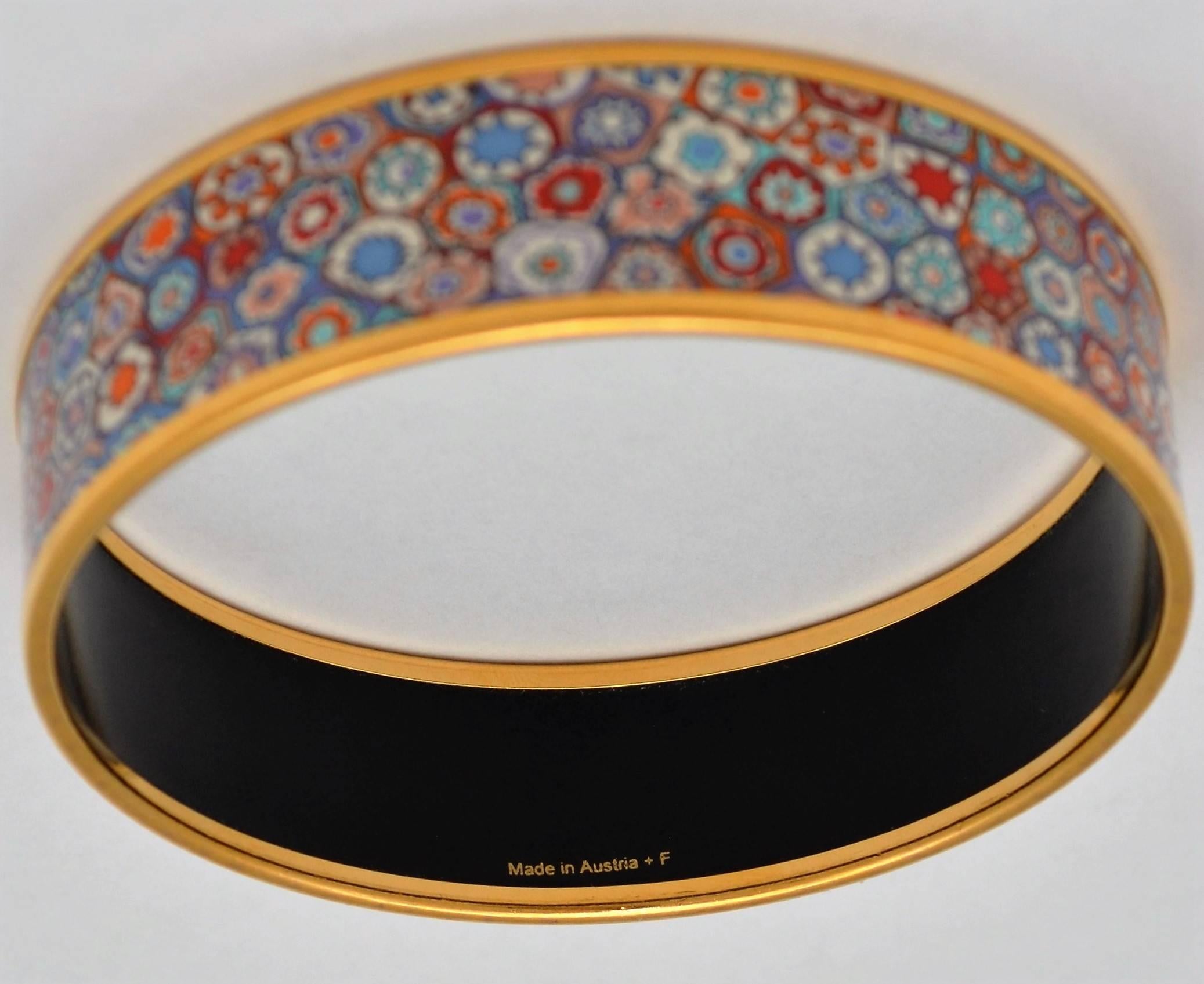 Hermes Paris Multicolor Floral Enamel Print Gold Bangle Bracelet Large Size 70

Hermes Paris bracelet is featured in a gold-tone metal and has a colorful enamel mosaic flower print. Made in Austria. Diameter measures 2.75 inches and is .75 inches