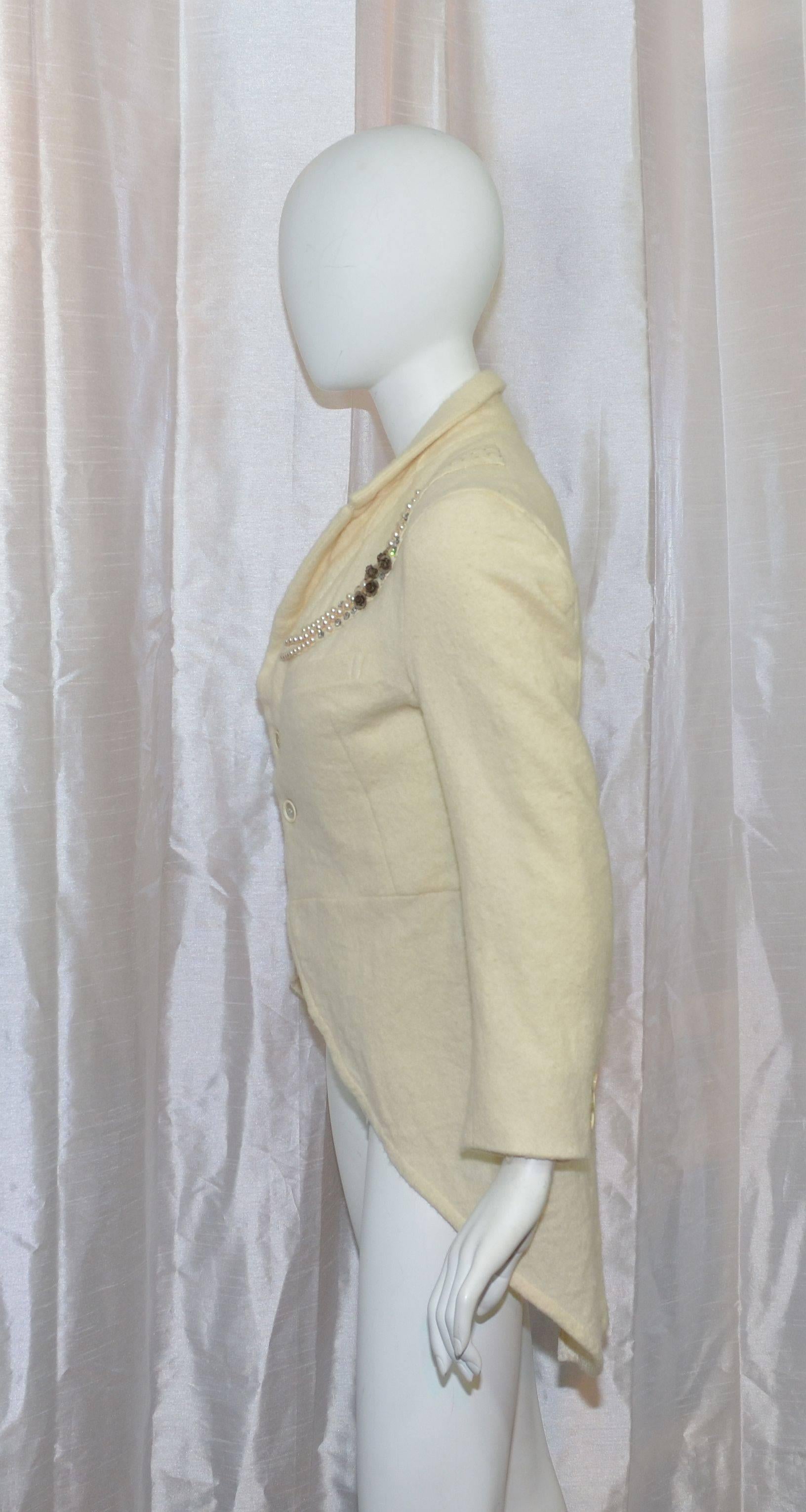 Comme des Garcons cutaway jacket 2006 Fall/ Winter collection featured in a cream-colored unlined wool fabric, two button closures at the front, one functional pocket at the bust, embellishing along the collar area by avant-grade French jewelry