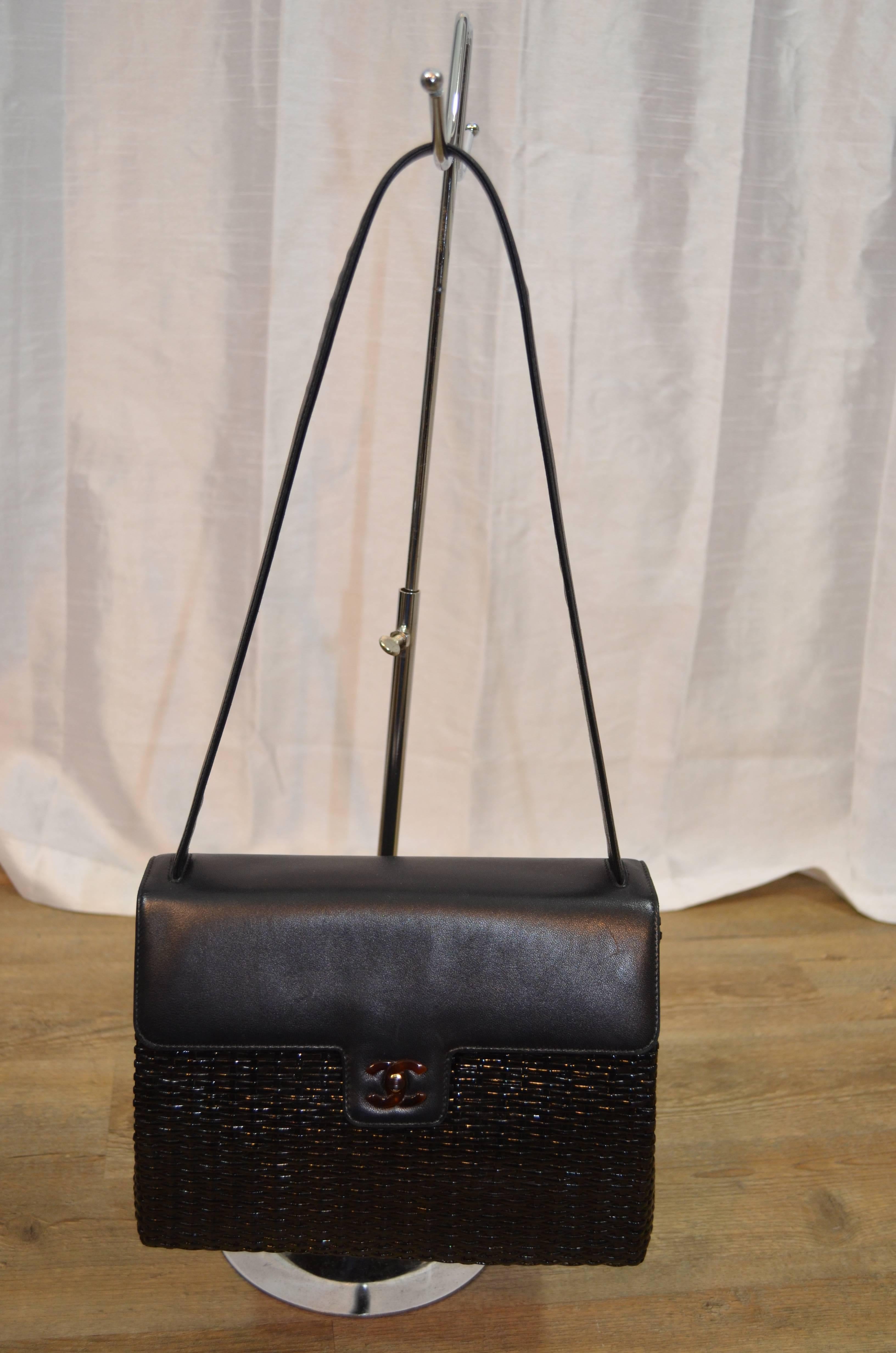 Chanel woven coated wicker and leather black box handbag with tortoise CC turnlock closure. Leather flap and leather shoulder strap. Fabric lining and 1 zipper pocket. Includes dustbin and serial number sticker. Overall excellent condition with wear