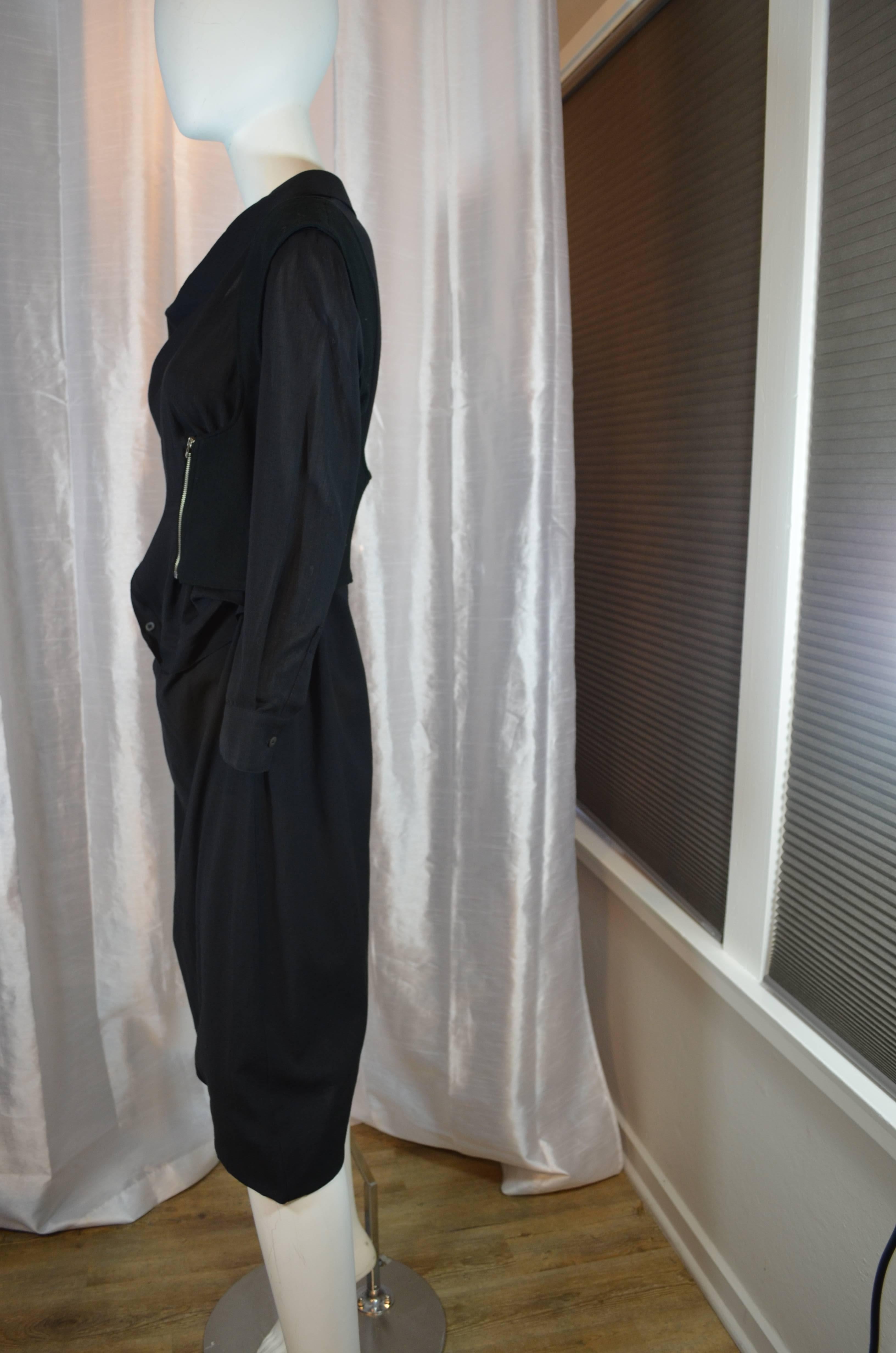 Avant-garde Hussein Chalayan black dress is asymmetrically constructed.  The cotton dress has a built in wool vest with asymmetrical zippers and the bodice has asymmetrical button up front.  The dress is a light weight cotton blend and the vest is
