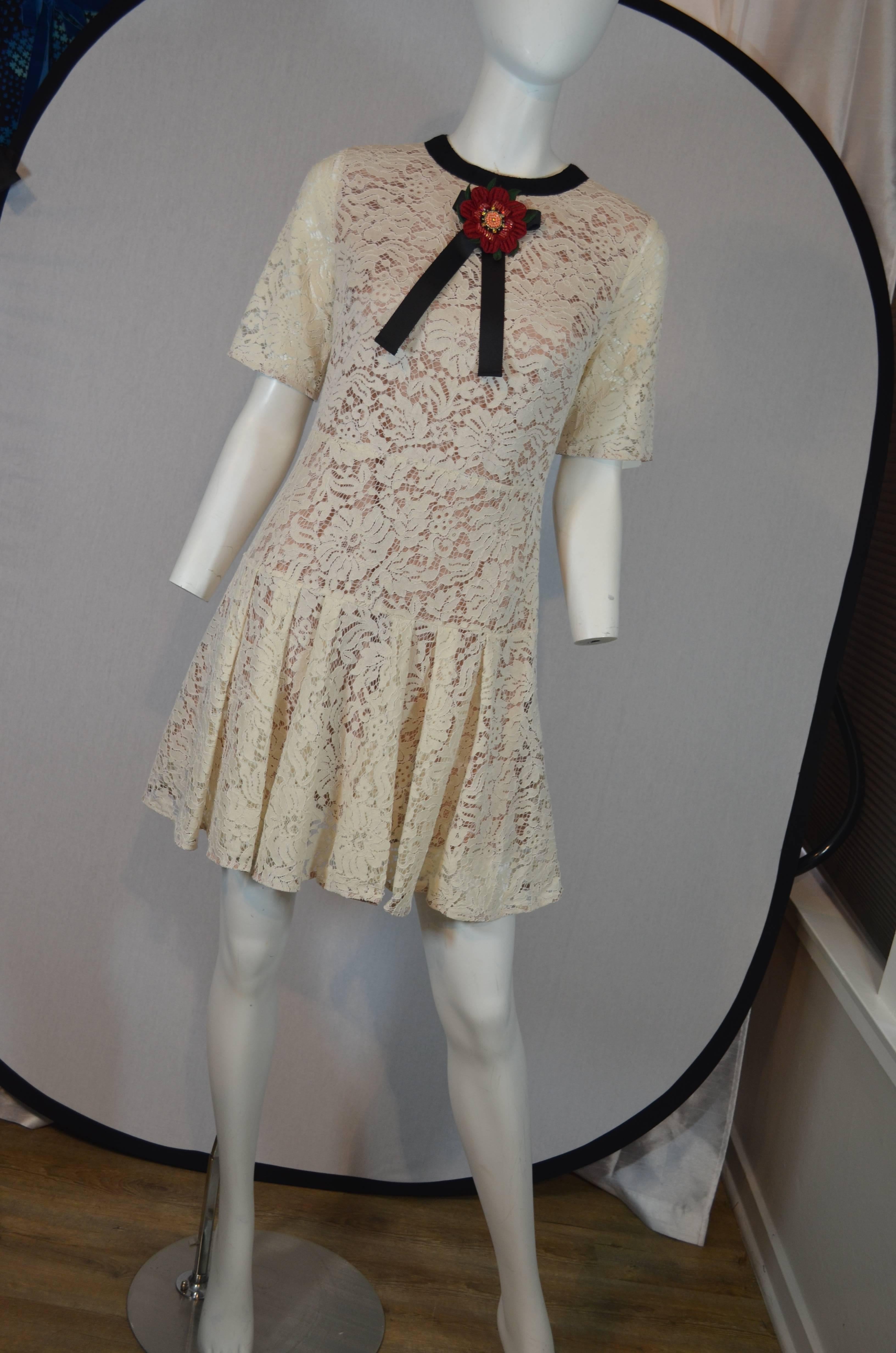 Contemporary Gucci Summer Lace Fit and Flare Short Sleeve Mini Dress
Cream lace dress with a nude lining features a back zipper, drop waist, fit and flare skirt, grosgrain neck trim and embellished flower bow tie pin. Short sleeves. Gucci tag at