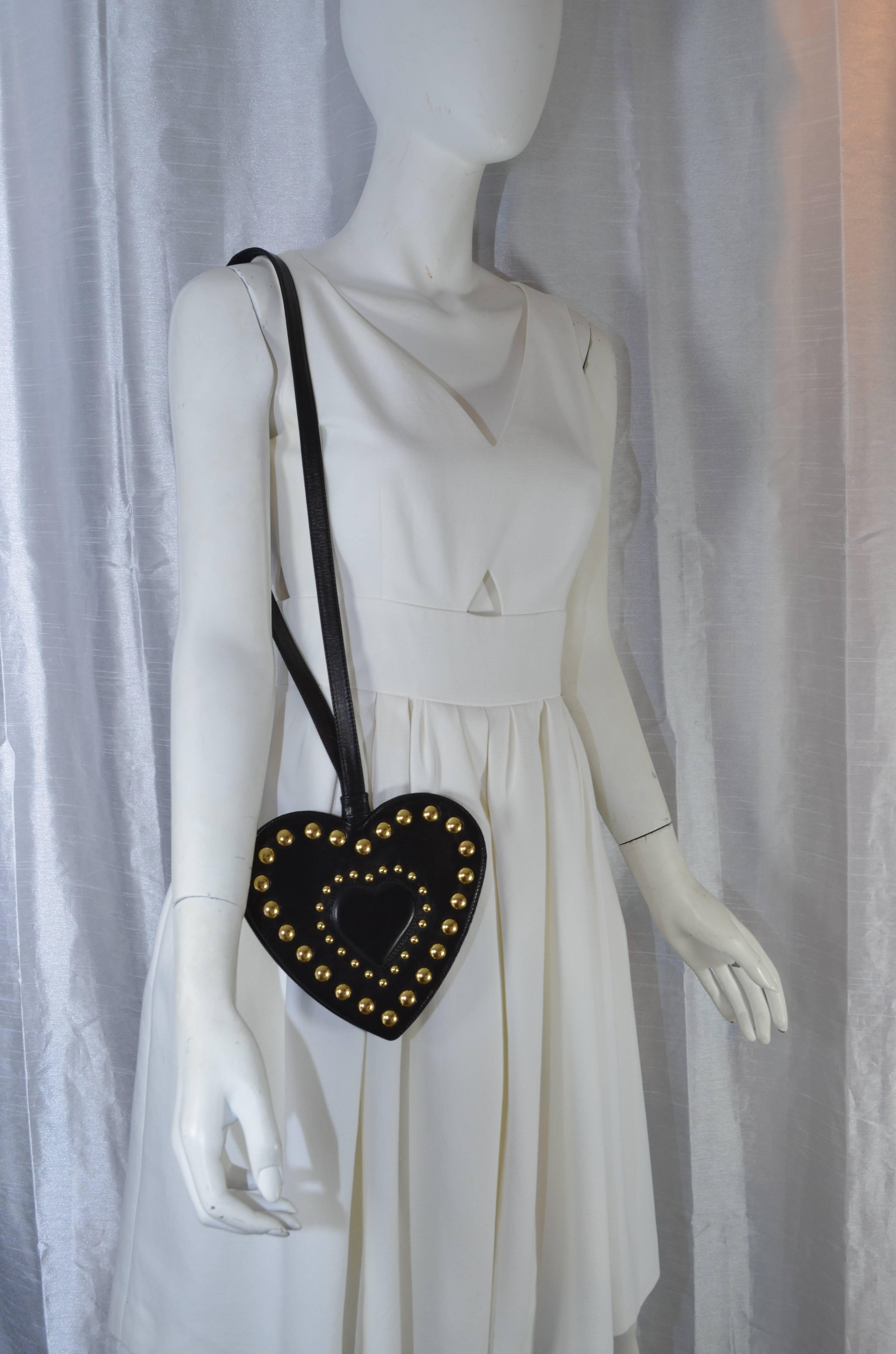 Moschino Redwall 1980's Black Leather Heart Studded Shoulder Purse

Heart shaped Moschino leather purse in black featuring gold metal accent studs. Back portion of bag is plain black. Magnetic button closure on the inside of the bag. Lightweight