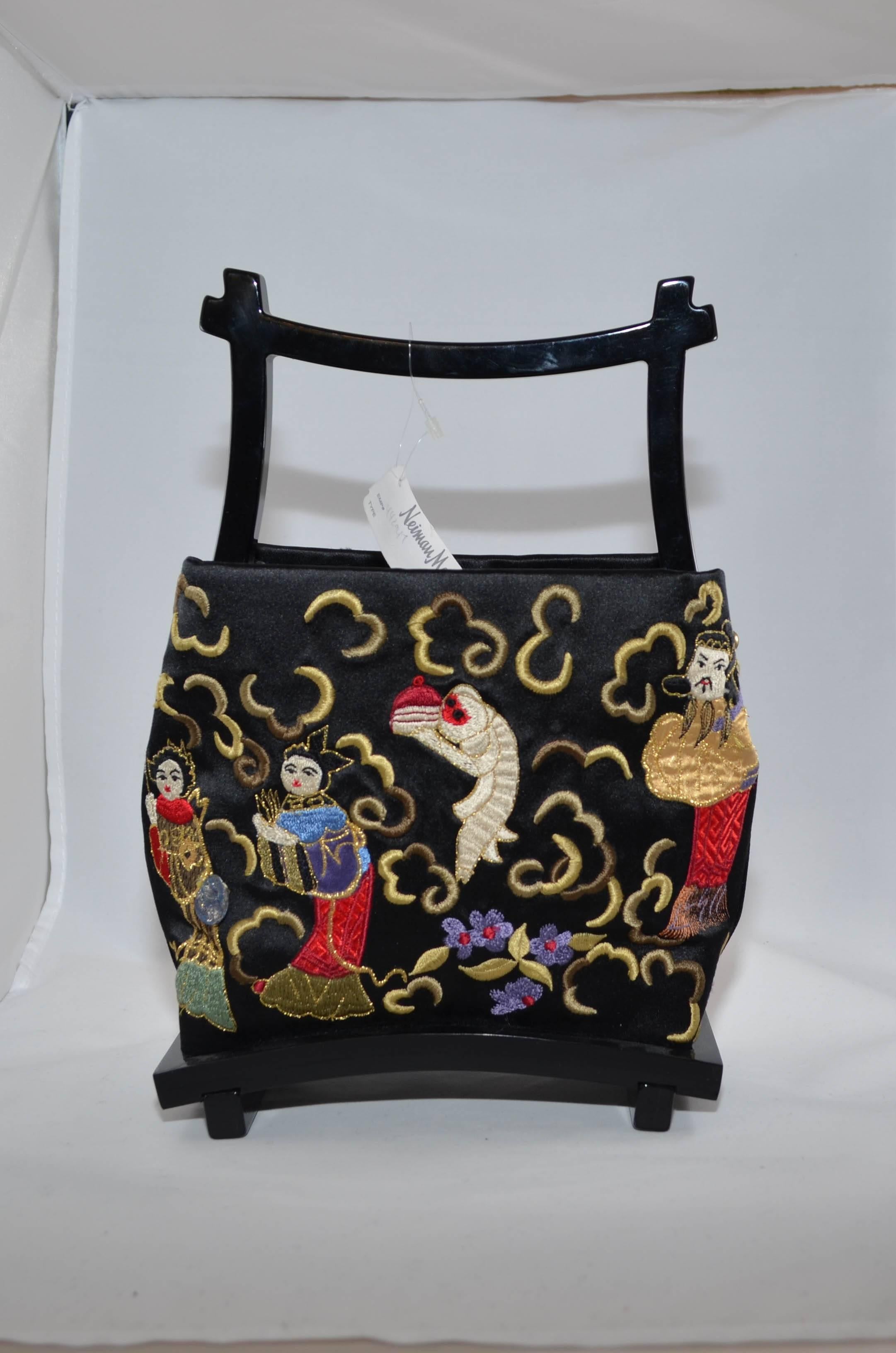 Natori Silk Embroidered Evening Bag. Black silk background with multicolored embroidery depicting a Chinese scene. Black lacquered wood frame. Excellent condition.
Measurements in inches: 
Height 6.5
Width 8
Depth 3
Handle Drop 2.5