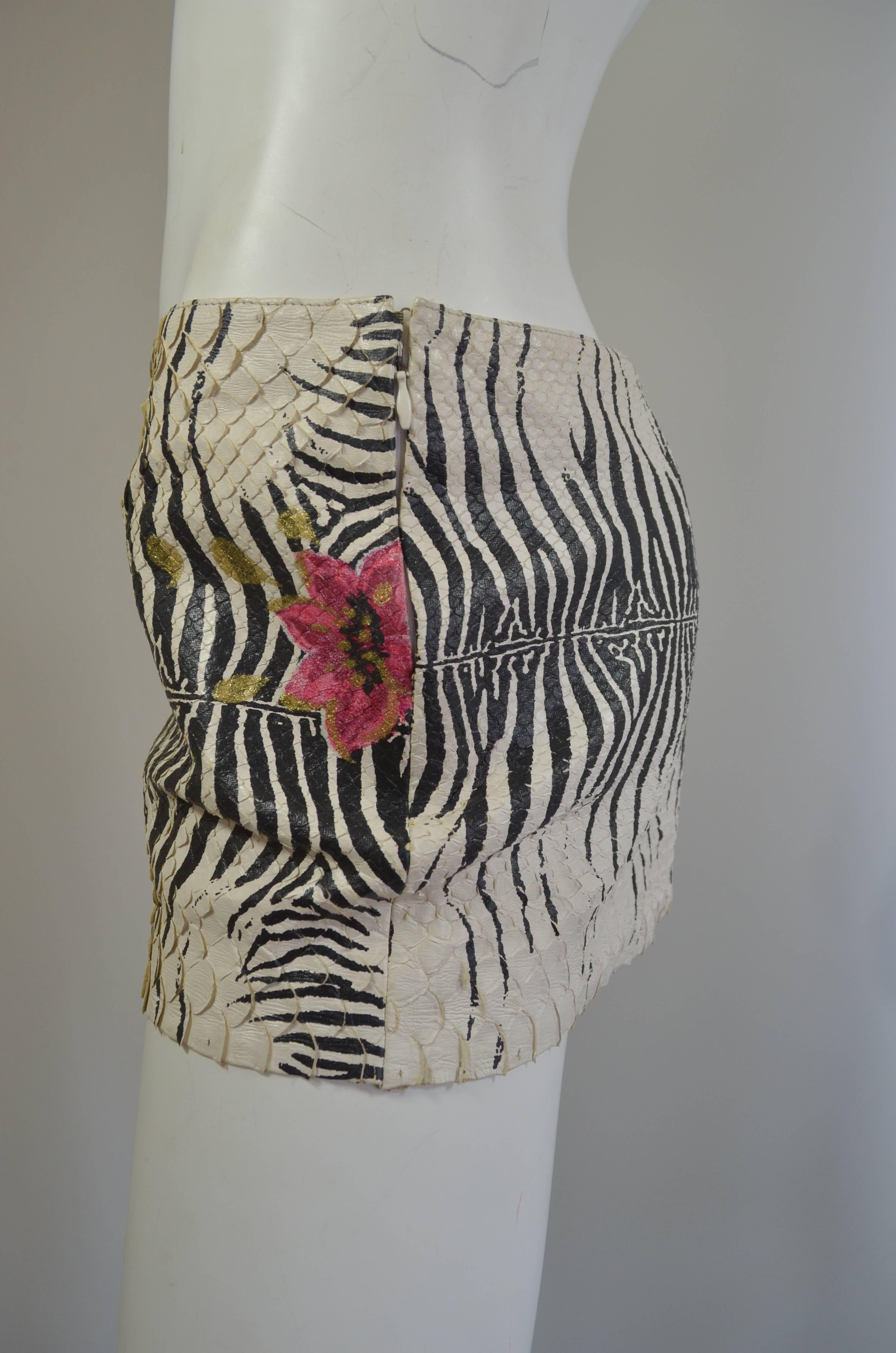 Roberto Cavalli micro mini skirt made from whitewashed French genuine snakeskin with black zebra design, and pink and gold camellias painted on the skin. Lined in signature Roberto Cavalli satin lining. Side zipper. Made in Italy. Excellent