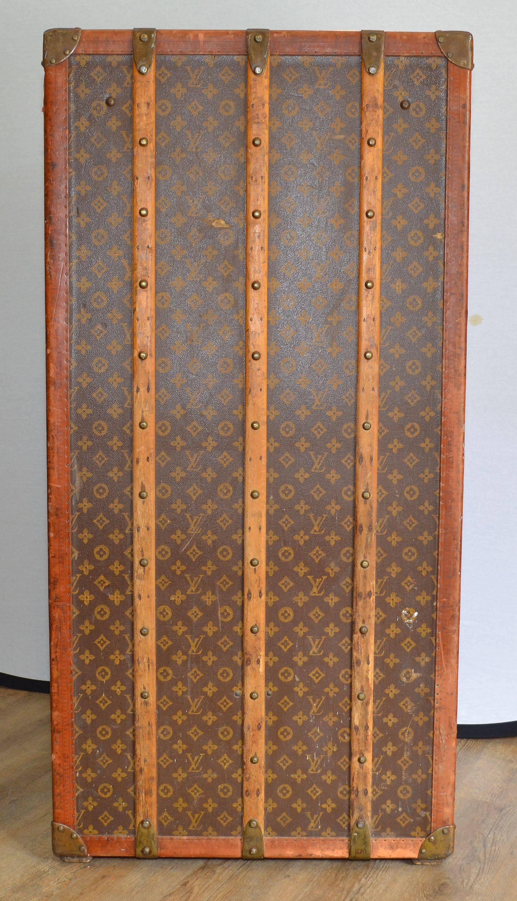Louis Vuitton trunk case featured in its signature monogram throughout with aged hardware (hardware has LV markings). Case has some visible dings and scratches as pictured. Interior retains original trays, removable case, hangers, and dust cover.