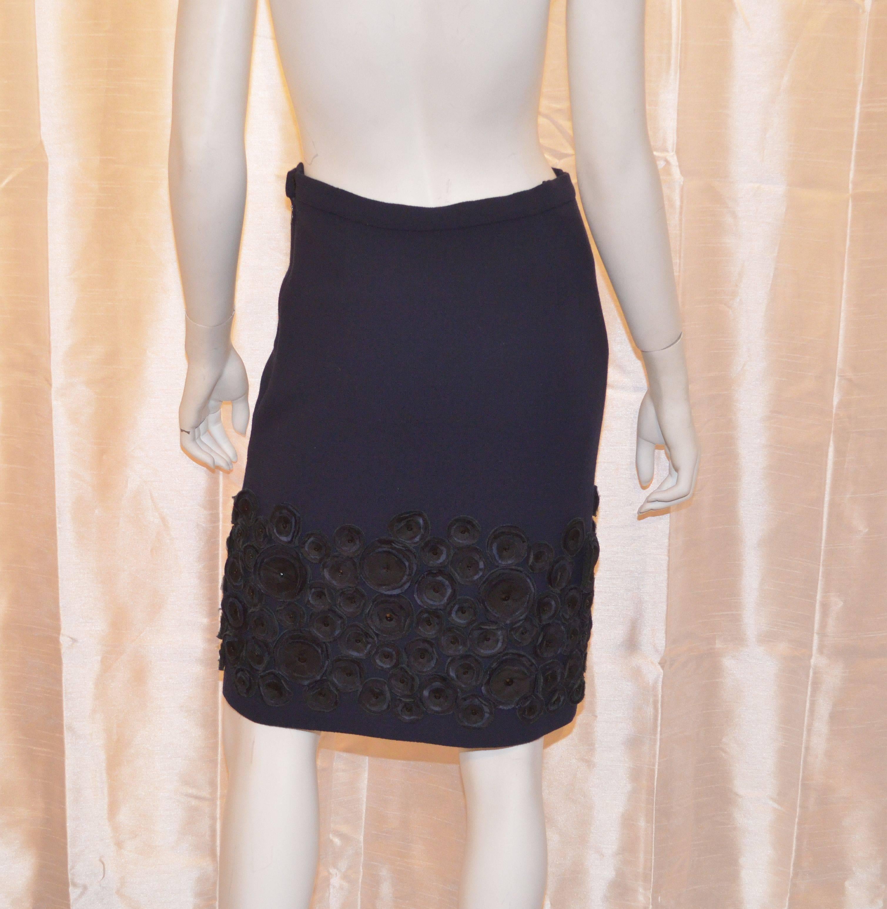 Skirt is 100% wool in a French navy blue color with black silk embellishing along the hem, side zipper and hook-and-eye closure, and fully lined in 100% silk. Size 4, Made in USA.

Measurements:
Waist - 26''
Hips - 35''
Length - 22''