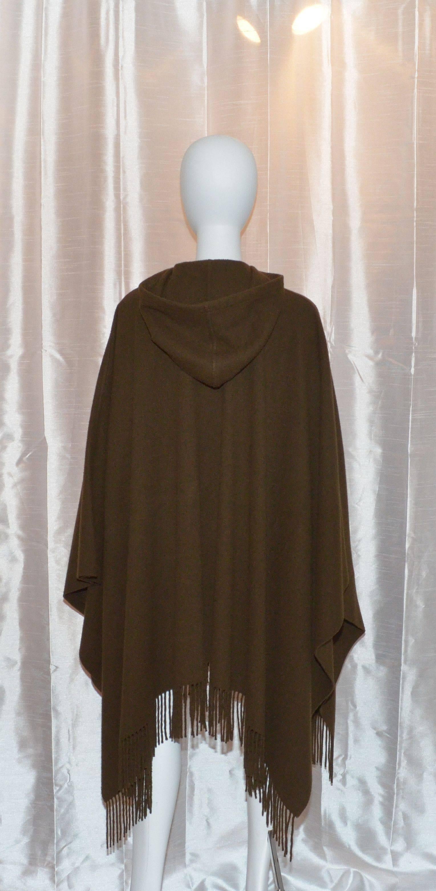 Hermes cape  / poncho features a chunky removable brass hook-and-eye closure at the neck, two large slip pockets, and is hooded. Cape also has a leather/cashmere optional waist tie and a fringe finish along the hem. Made in