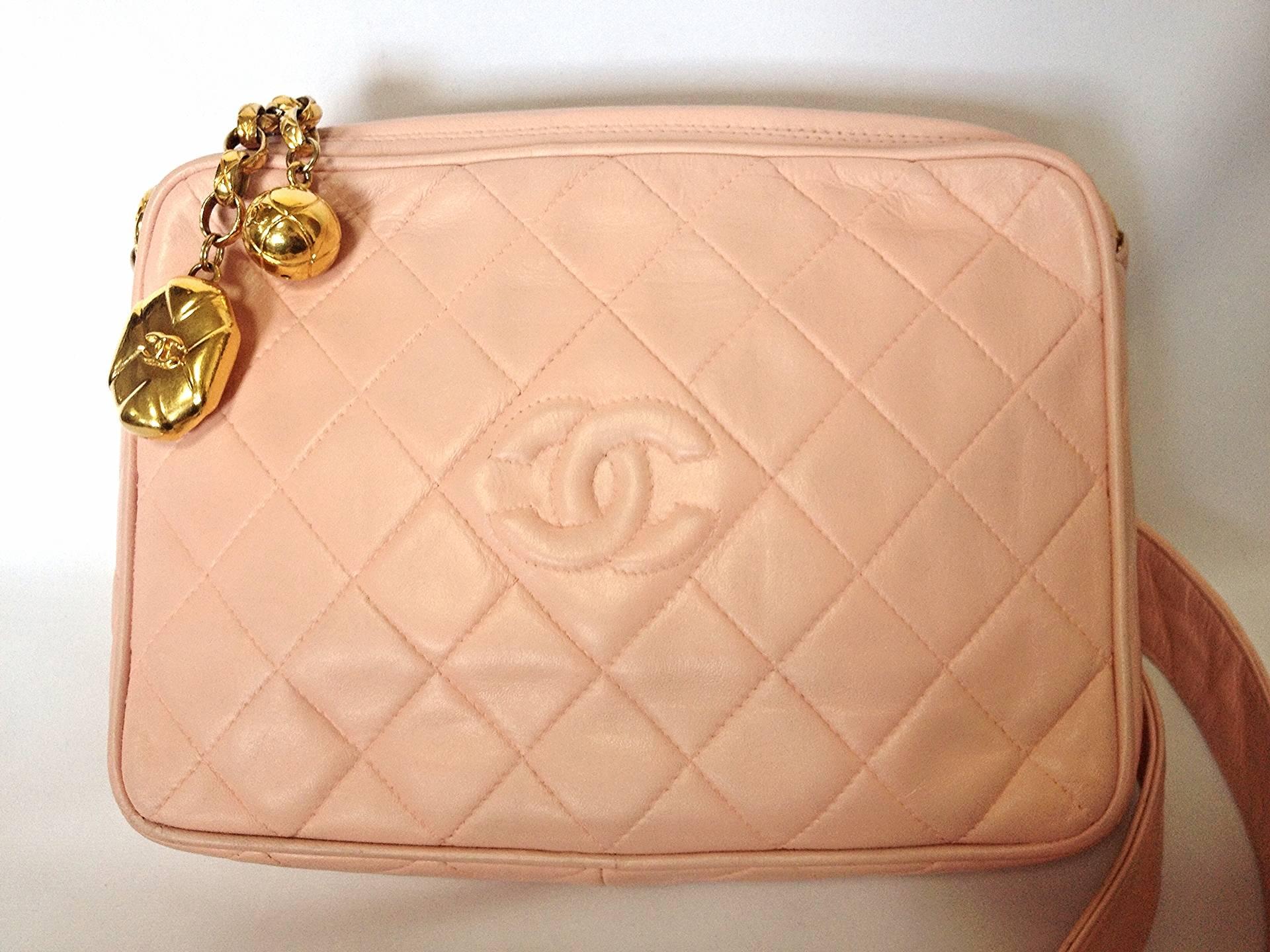 Introducing one of the cutest pieces from CHANEL, milky pink color lambskin medium size shoulder bag with dangling logo charms. Rare color and style. Will definitely be one of your daily use vintage Chanel bags for sure.

Featuring 2 golden CC