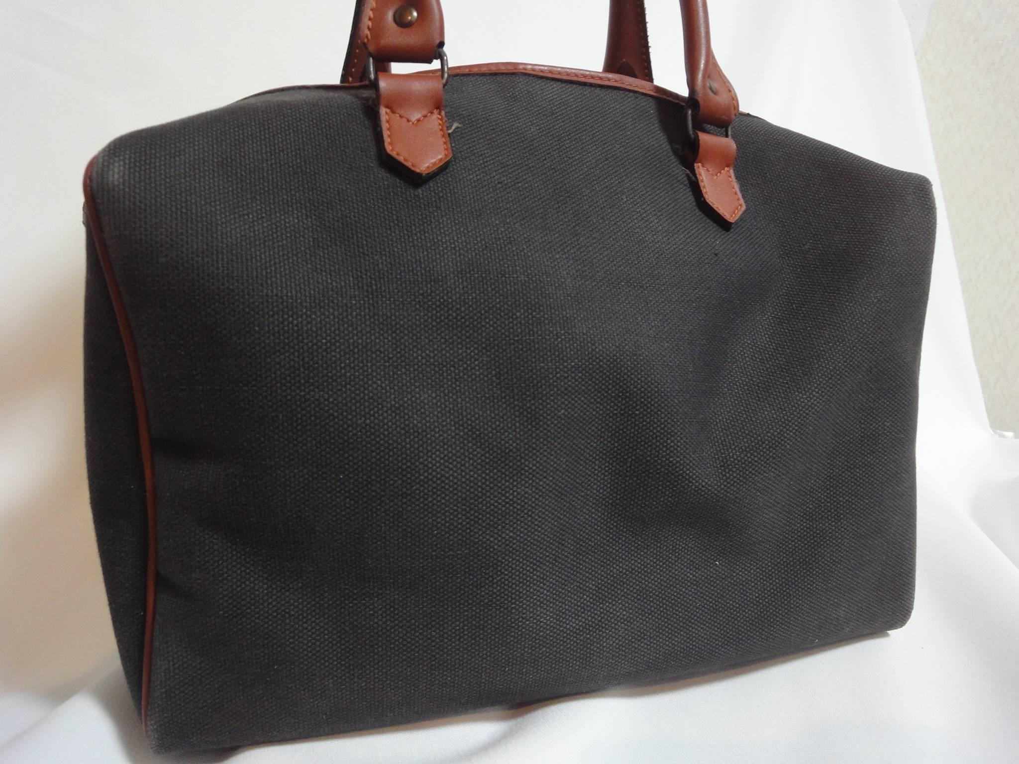 Vintage Yves Saint Laurent charcoal grey canvas and brown leather travel bag, daily use duffle purse. Classic unisex style YSL purse.

This is a vintage classic canvas and leather duffle bag from Yves Saint Laurent in approximately from the 80s.