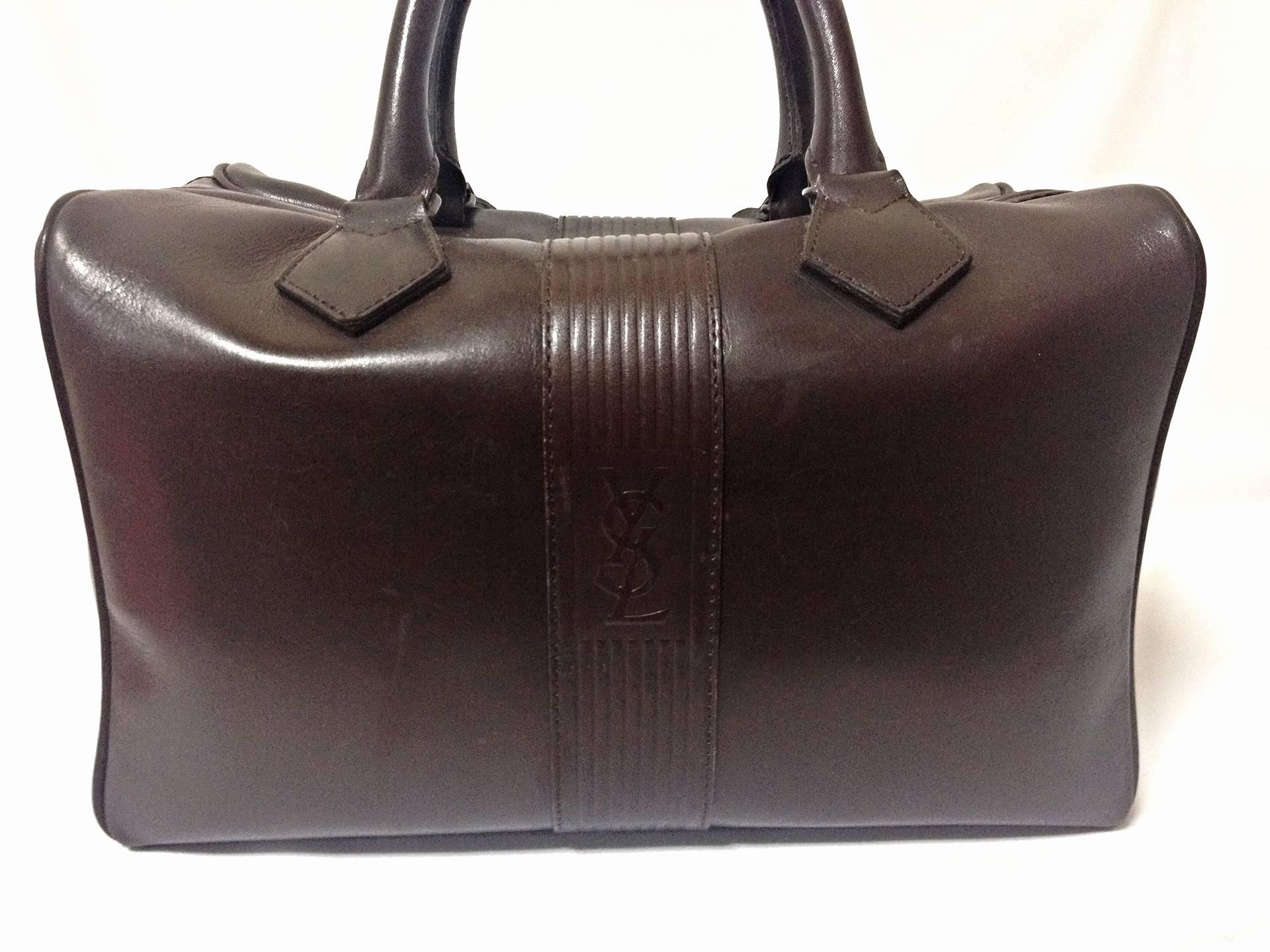 This is a vintage classic design leather handbag/mini duffle bag from Yves Saint Laurent in approximately from the late 80's through the early 90's. 
Great to be one of your daily-use bags as well as a few day travel bag.

Featuring its iconic