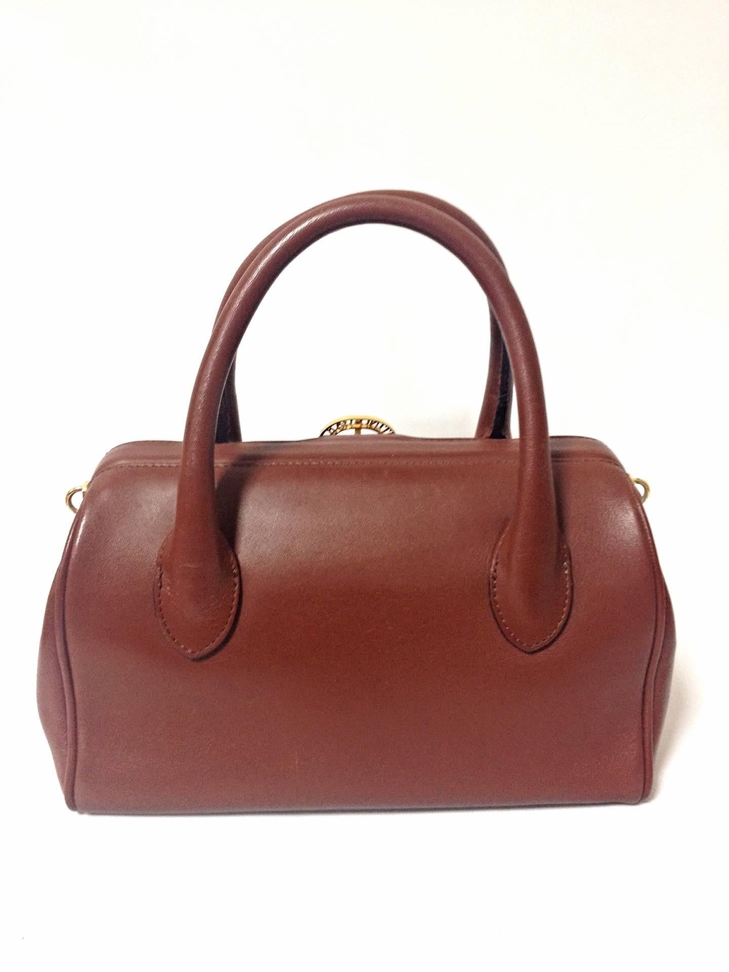 Vintage Valentino Garavani, brick brown leather mini handbag with golden logo cut out motif. Classic Valentino purse for any occasions.

This is the vintage Valentino Garavani brick brown leather purse approx early 90's.
Classic style that fits