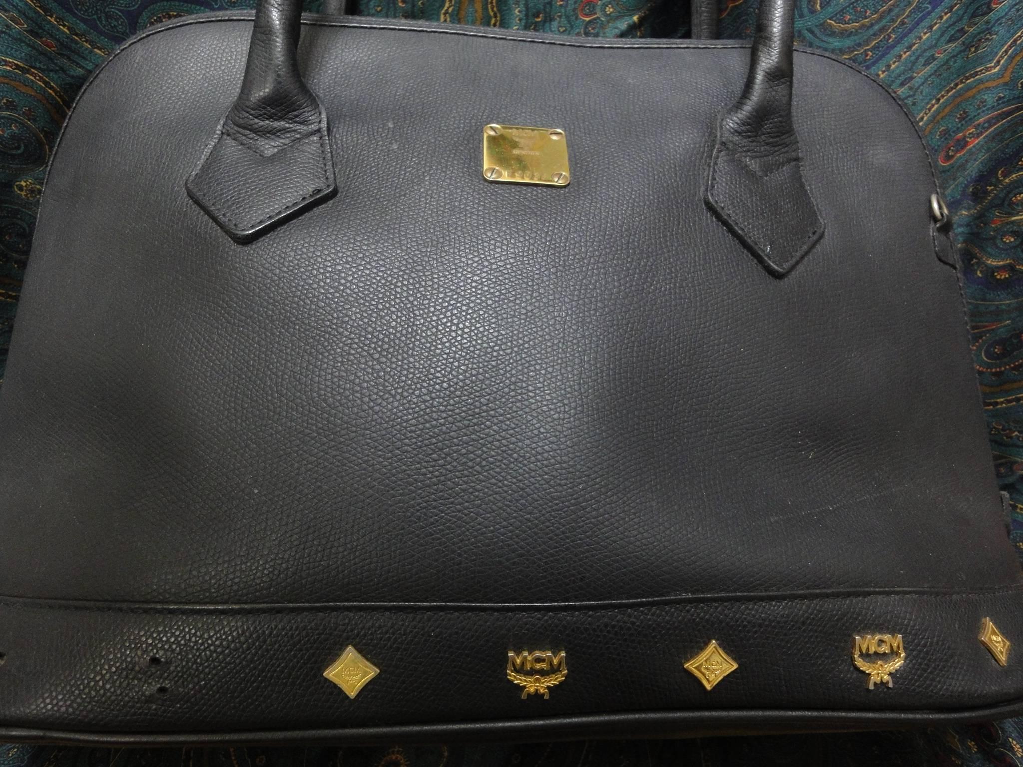 Vintage MCM black bolide style bag with gold tone metal studded charms. Designed by Michael Cromer. Masterpiece purse for unisex use.

MCM has been back in the fashion trend again!!
Now it's considered to be one of the must-have designer in