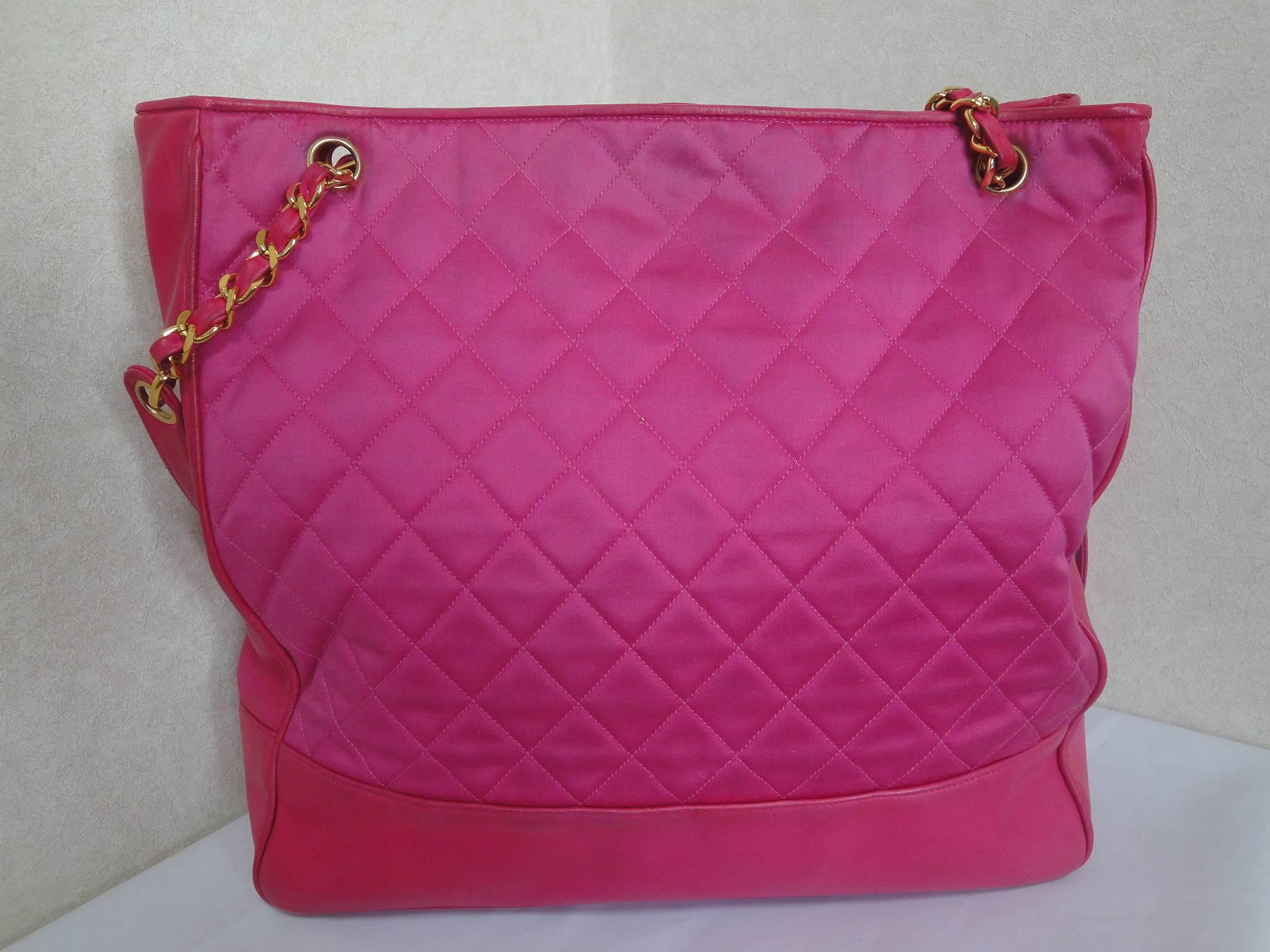 Vintage CHANEL bright pink chain shoulder tote bag with quilted satin and calfskin combo. Gold tone CC ball charm. Hot, think spring

This is a vintage hot pink large tote bag with gold chain straps from Chanel in the 90s.
Rare color for the