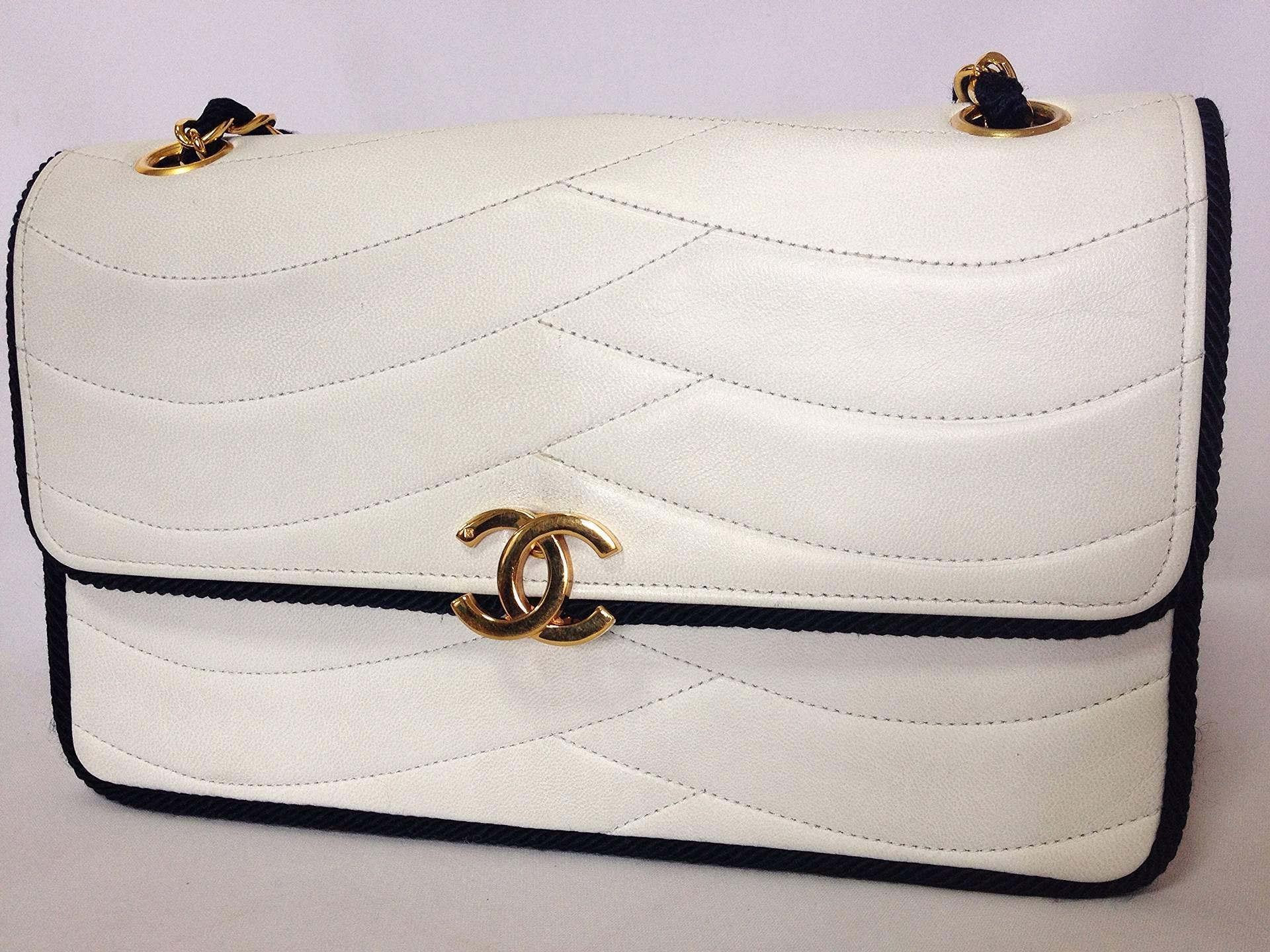 MINT. 80's rare vintage Chanel white flap bag with navy rope string and gold chains. Very rare purse from the era.

This is a very rare vintage CHANEL white lambskin purse with the navy rope strap in the 80's.
Featuring the zipper by ECLAIR,