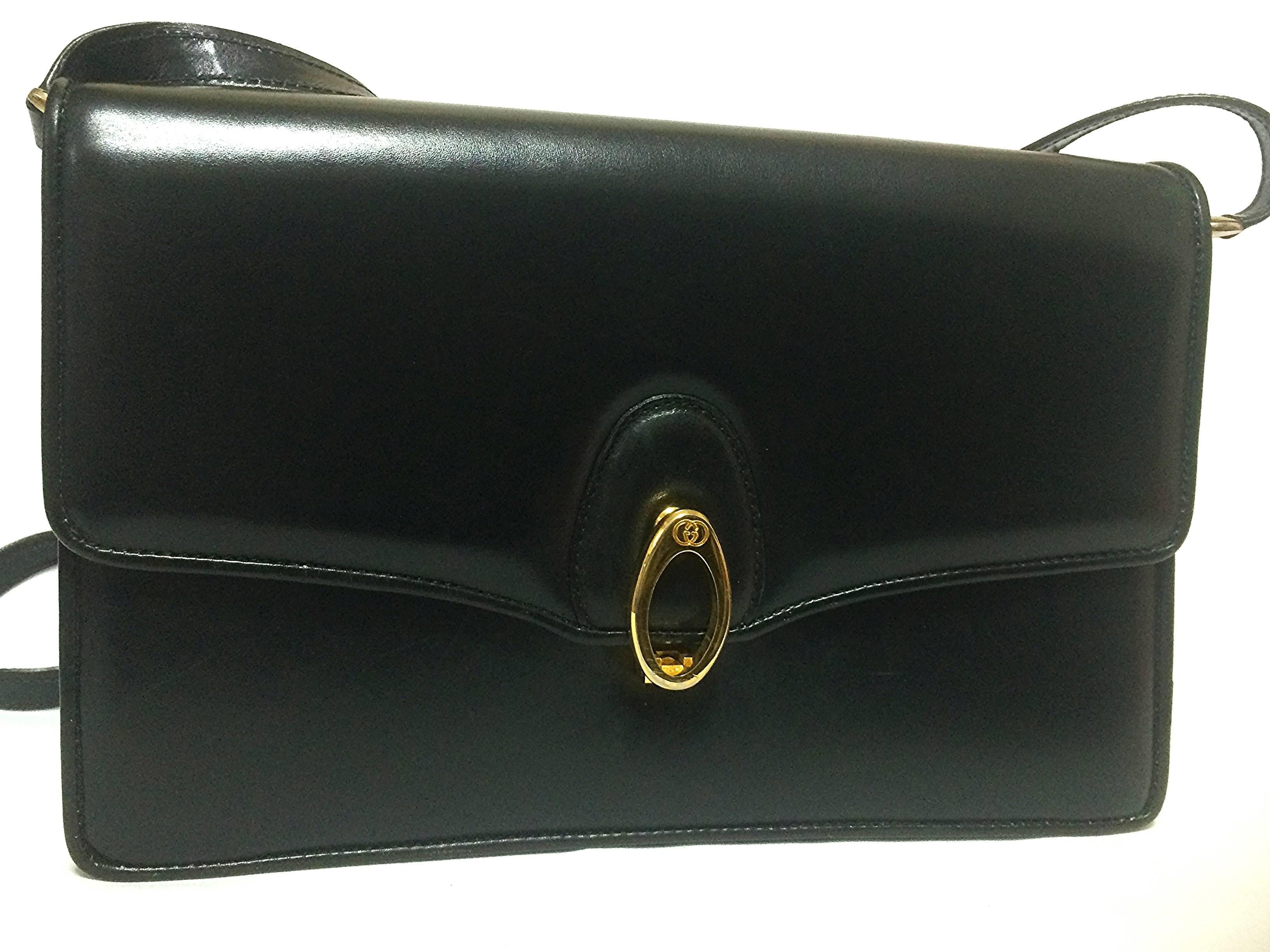 1980's vintage Gucci black leather shoulder bag with golden logo embossed oval motif closure. 

Introducing a masterpiece, leather shoulder from Gucci back in the 80's.
Very sophisticated purse that would never go out of style.
The front golden