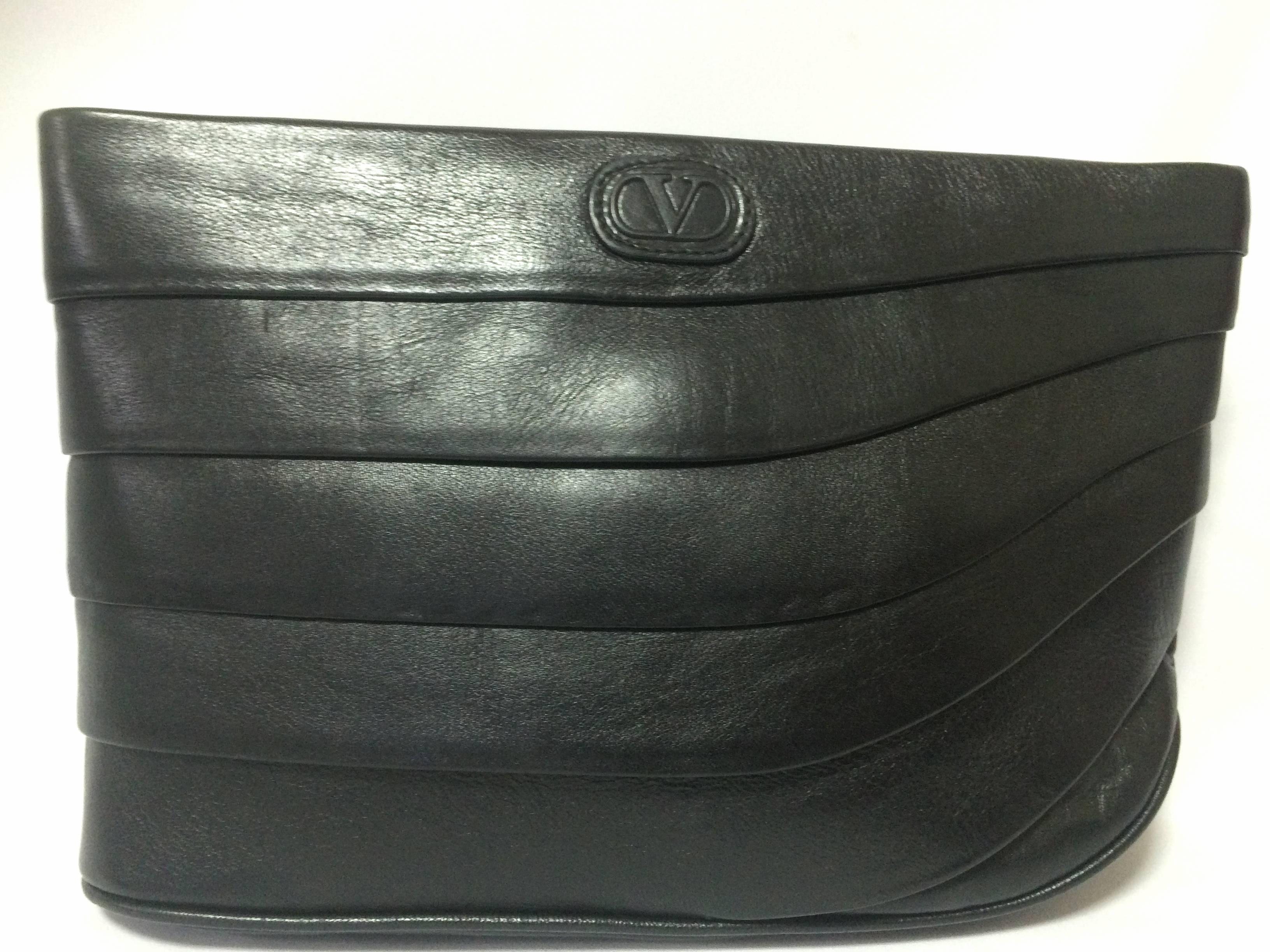 1980’s Vintage Valentino Garavani black leather wave layered design clutch bag, purse with V logo. Classic unisex purse for daily use.

This is a vintage clutch purse, purse from Valentino Garavani from the 80's. Perfect daily use bag for unisex