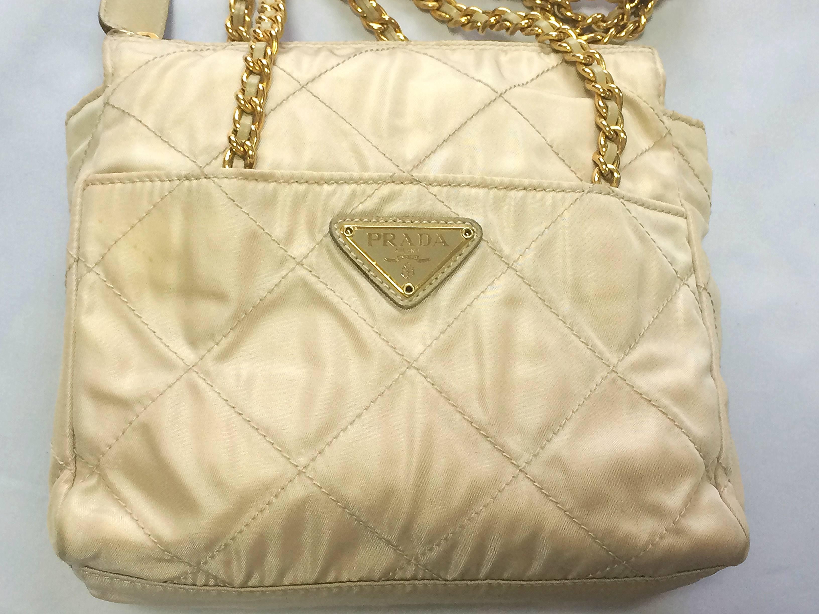 1990s. Vintage Prada classic quilted nylon ivory shoulder bag with gold tone chain straps. Must have. LAMPO zipper. 

Introducing a classic nylon mini shoulder bag from Prada from the 90s.
Perfect vintage purse for any occasion through the
