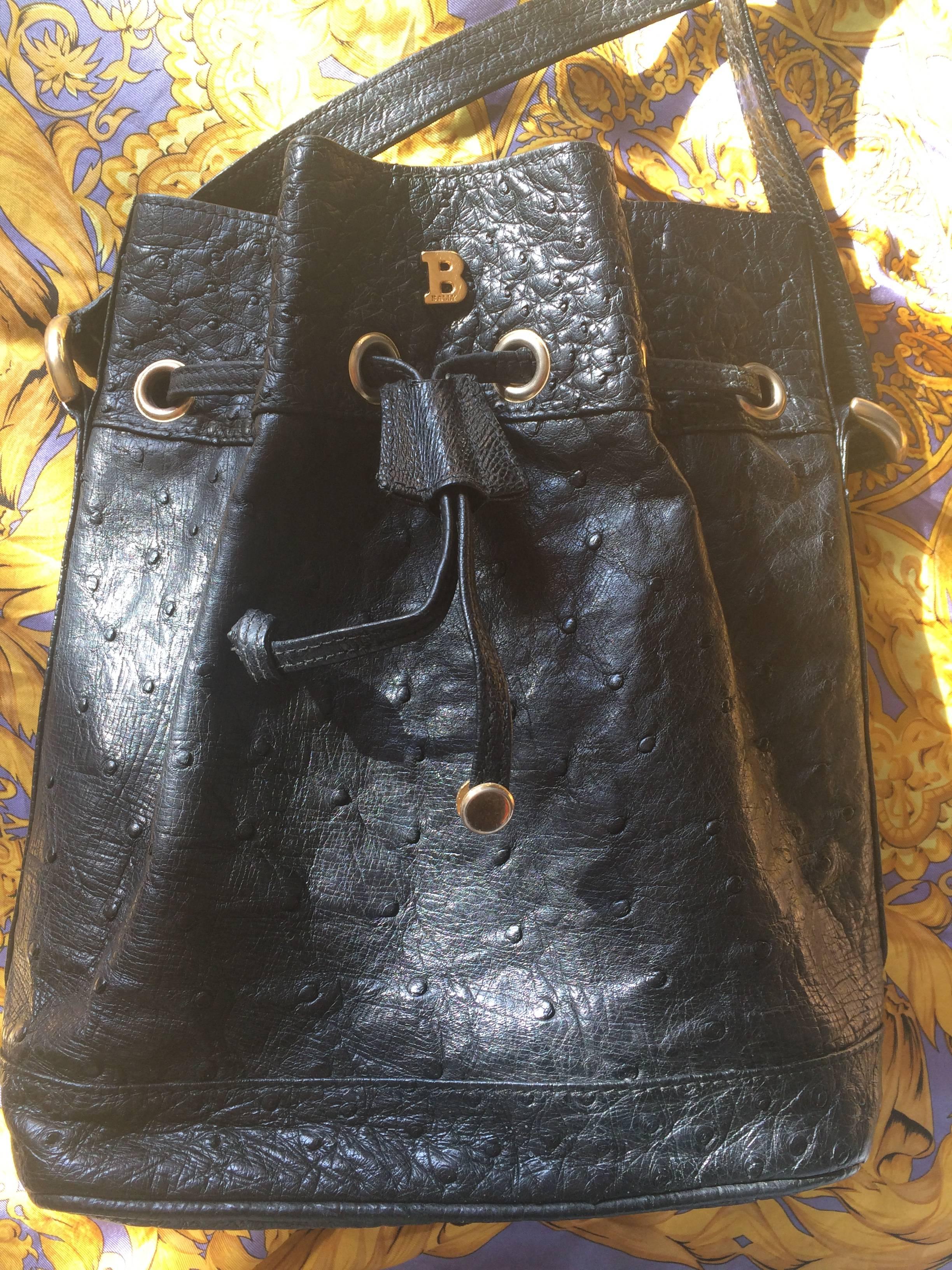 1980's vintage BALLY genuine black ostrich leather hobo bucket shoulder bag with golden B logo and drawstrings.

This is a vintage Bally genuine ostrich leather shoulder bag made out of genuine ostrich leather from the 80s.
This classic purse