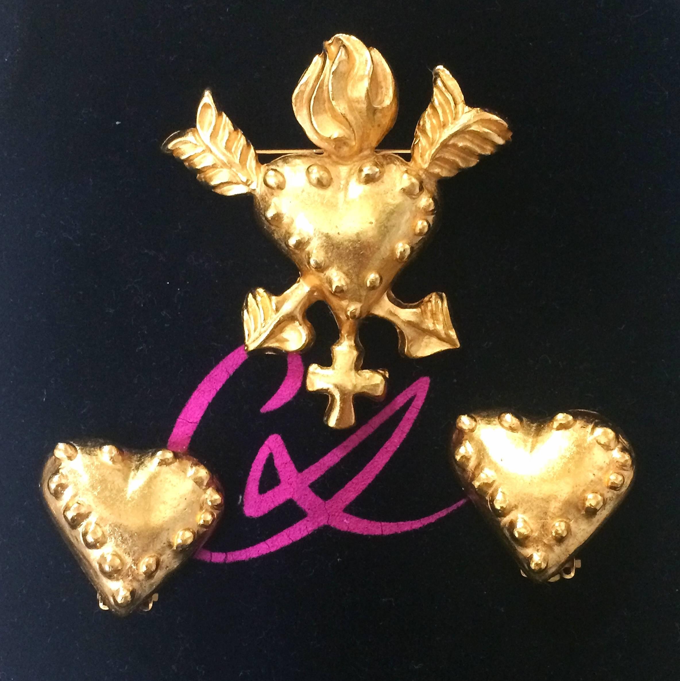 1990s. Vintage Christian Lacroix golden heart and arrow motif brooch, hat pin, jacket pin, and heart earrings set. Perfect gift jewelry.

Fun, Chic and Gorgeous jewelry piece set, brooch and matching earrings from Christian Lacroix.
Heart and