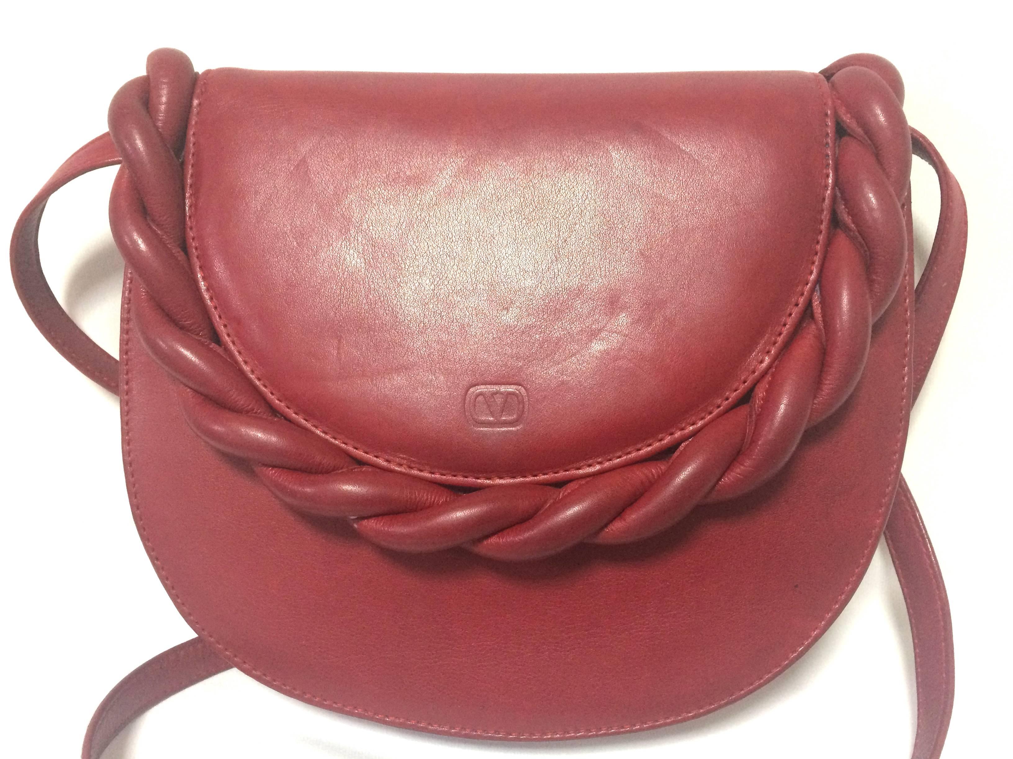 1990s. Vintage Valentino Garavani deep cherry red leather shoulder bag with twist motif and V embossed logo.

Introducing another rare masterpiece shoulder bag from Valentino Garavani back in the early 90's. Unique oval shape bag in deep cherry