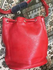 Vintage MCM genuine leather red hobo bucket shoulder bag with gold tone motifs.