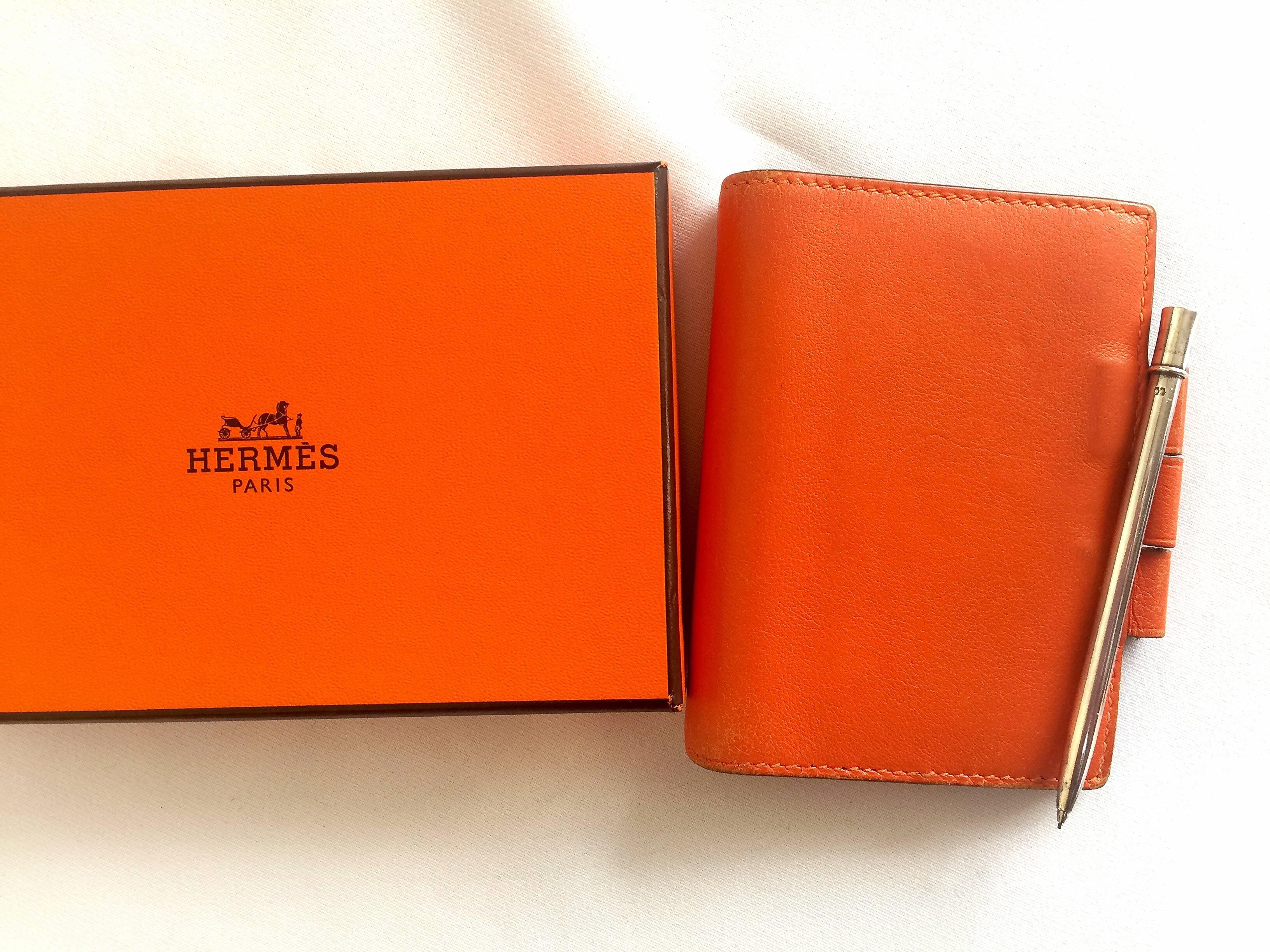 Vintage HERMES genuine orange leather diary, schedule book cover PM with silver mechanical pencil. Perfect professional stationery.

Introducing a  vintage diary/schedule book leather cover PM size from HERMES.
Perfect vintage stationery for