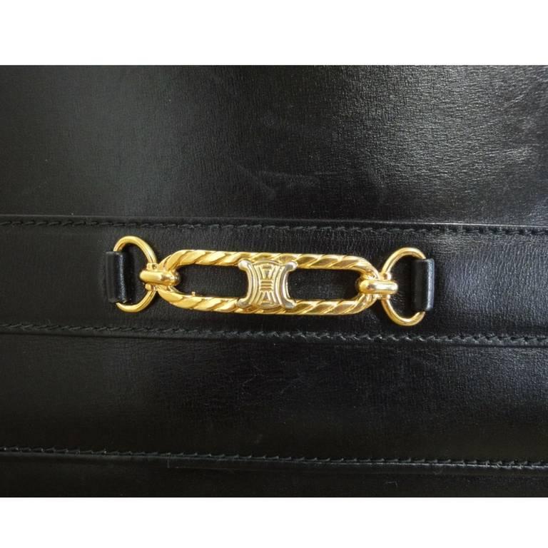 1980s. Vintage Celine black calfskin leather clutch bag with iconic golden blason macadam charm at front. riri zipper.

This is a vintage black leather clutch purse from Celine approx from the 80s.
It is in an great vintage condition though it shows