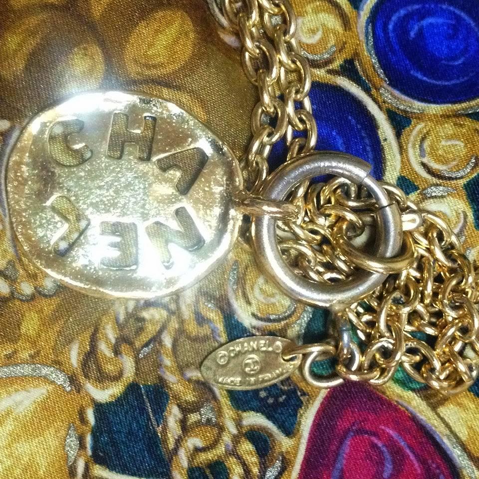 Women's Vintage CHANEL golden chain necklace with cutout logo coin charm.