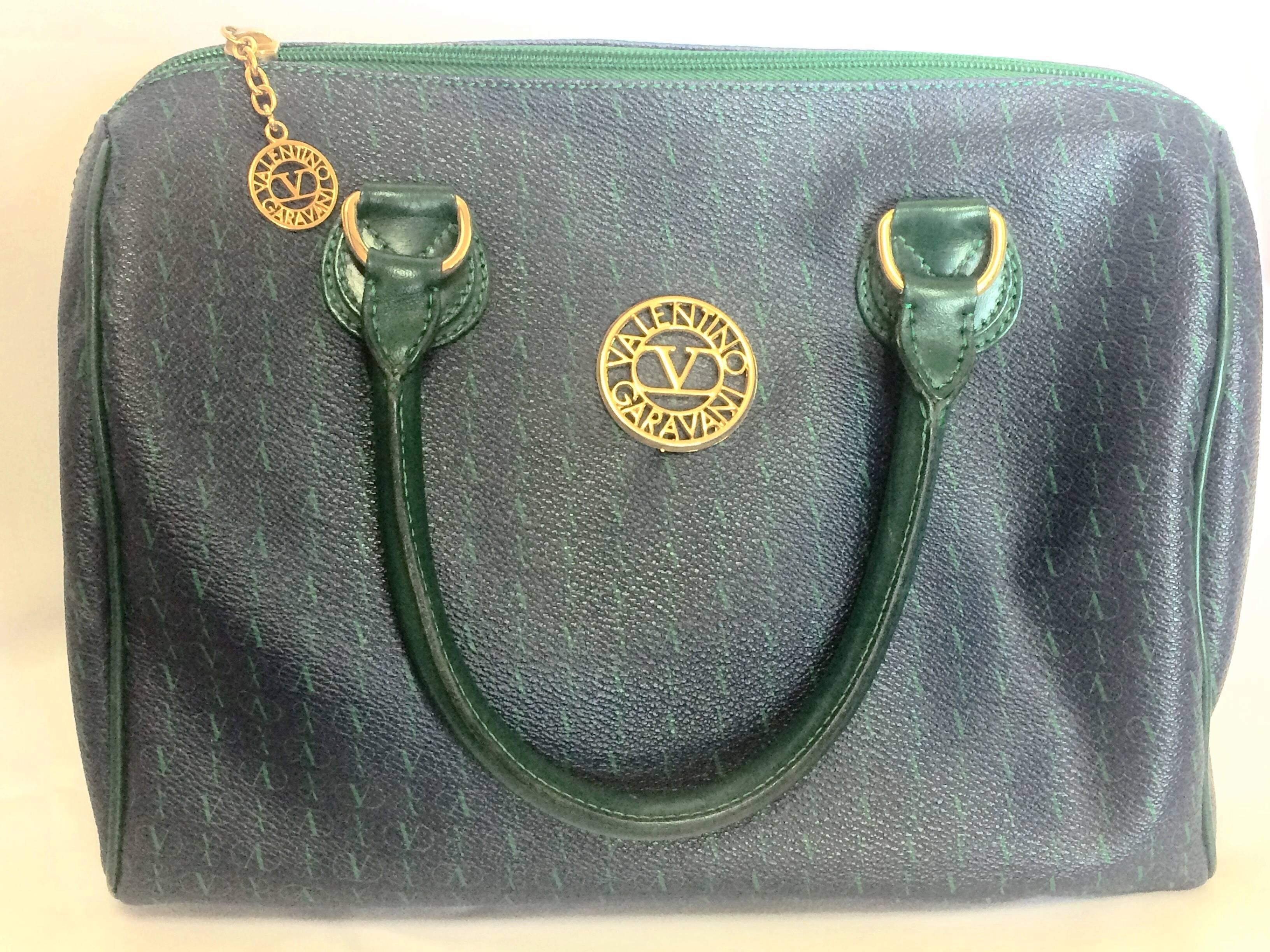 1990s. Vintage Valentino Garavani blue and green speedy bag style handbag with golden logo cutout motifs. Valentino purse for daily use.

This is the vintage Valentino Garavani blue and green handbag purse approx early 90's.
Classic Speedy bag style