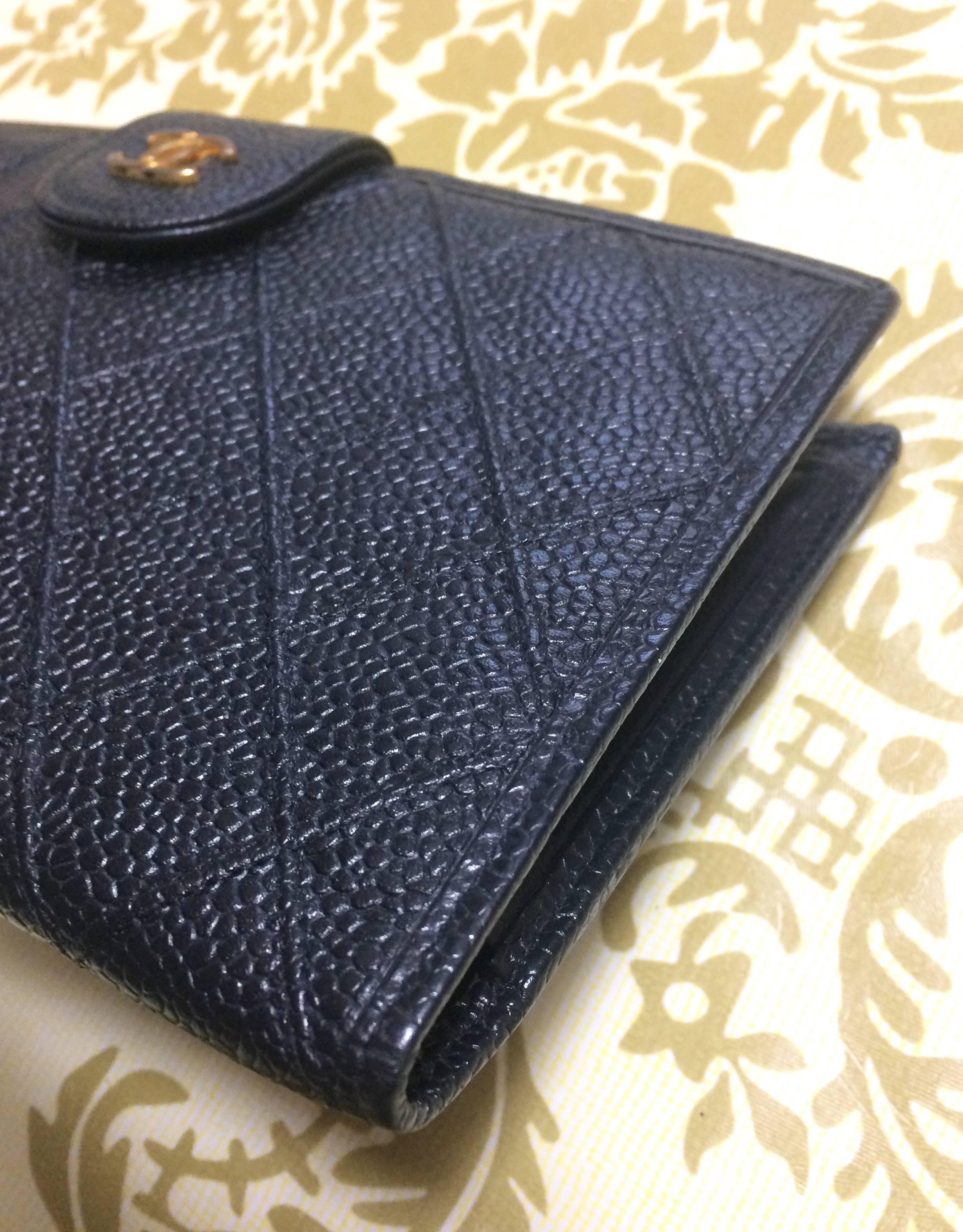 Women's or Men's Vintage CHANEL black caviar leather wallet with stitches and gold tone CC motif.