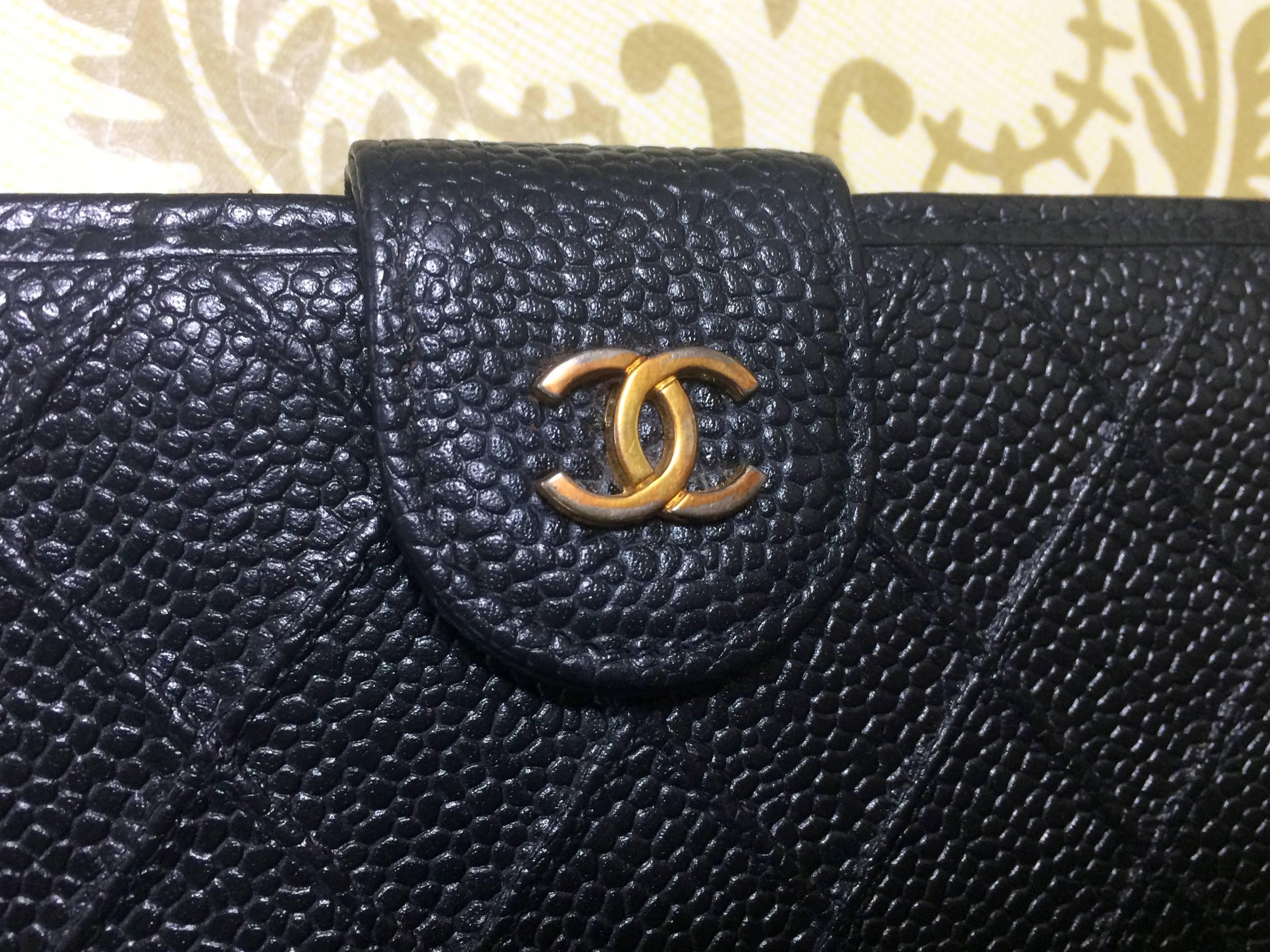 Black Vintage CHANEL black caviar leather wallet with stitches and gold tone CC motif.