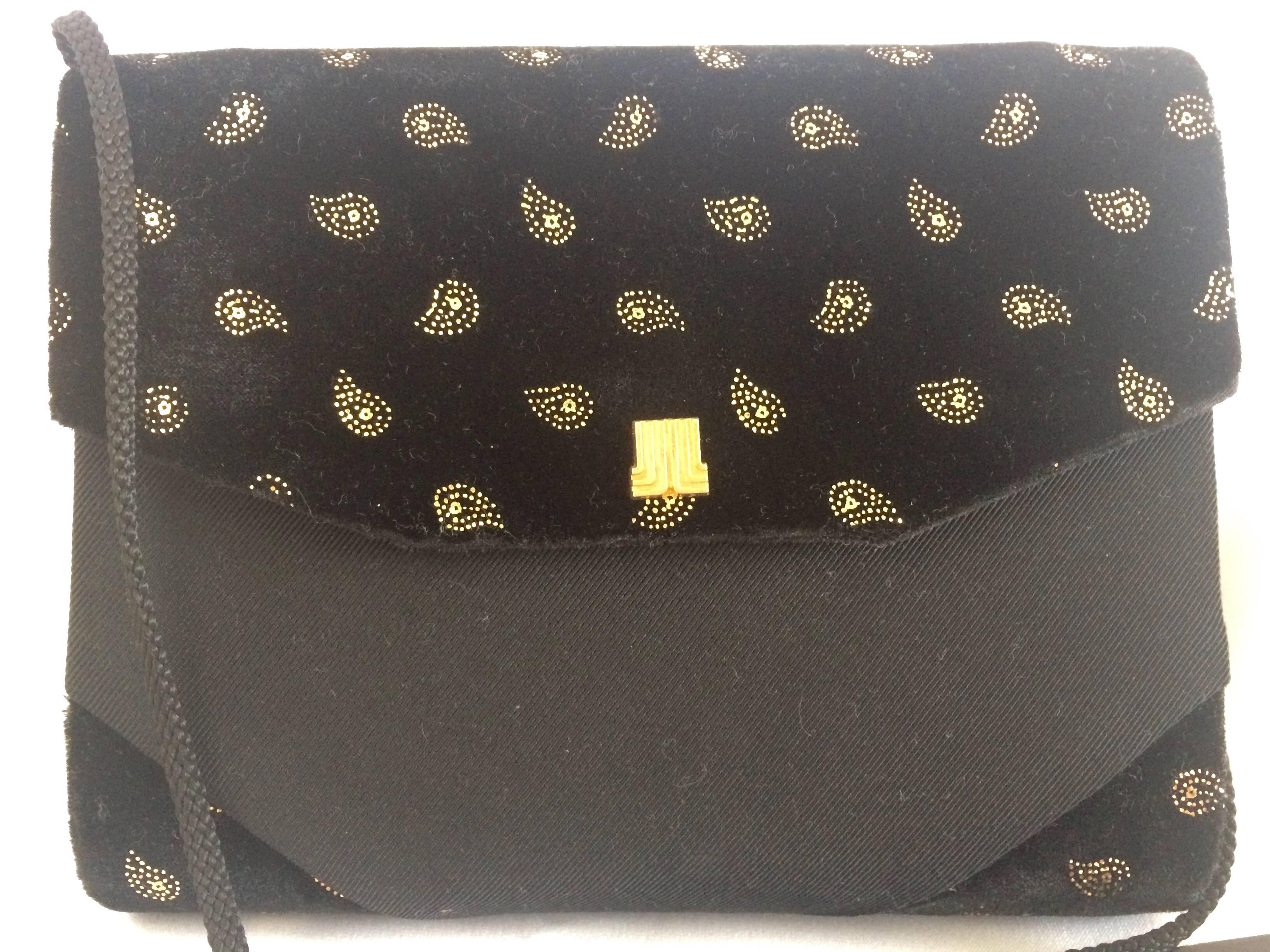 1980s. Vintage LANVIN black velvet and fabric clutch shoulder bag with golden allover paisley prints.

Introducing a vintage LANVIN clutch shoulder bag back in the 80's.
Featuring its iconic golden logo motif on the flap.

Golden mini paisley prints