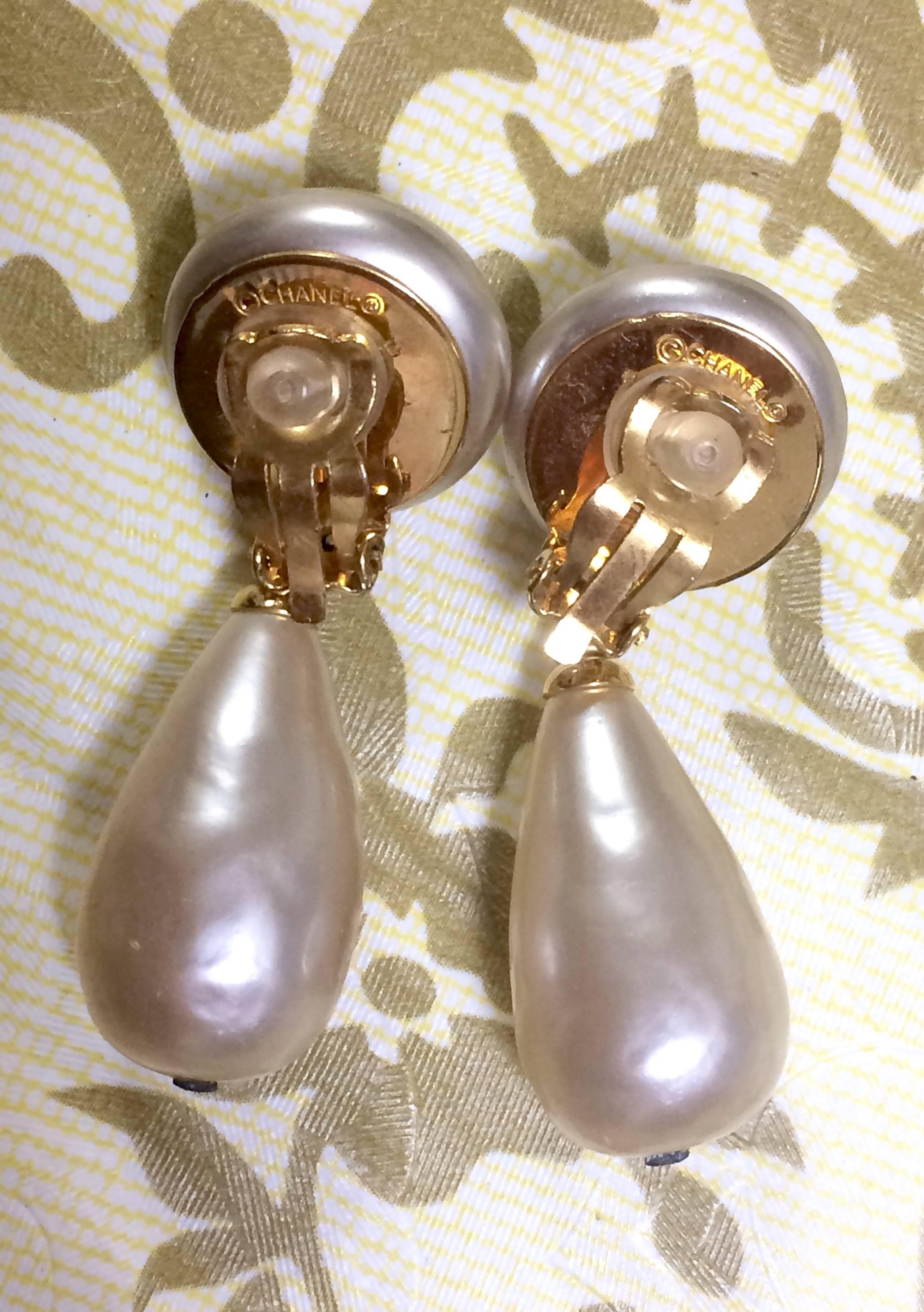 Women's Vintage CHANEL white teardrop faux pearl dangling earrings with golden CC mark.