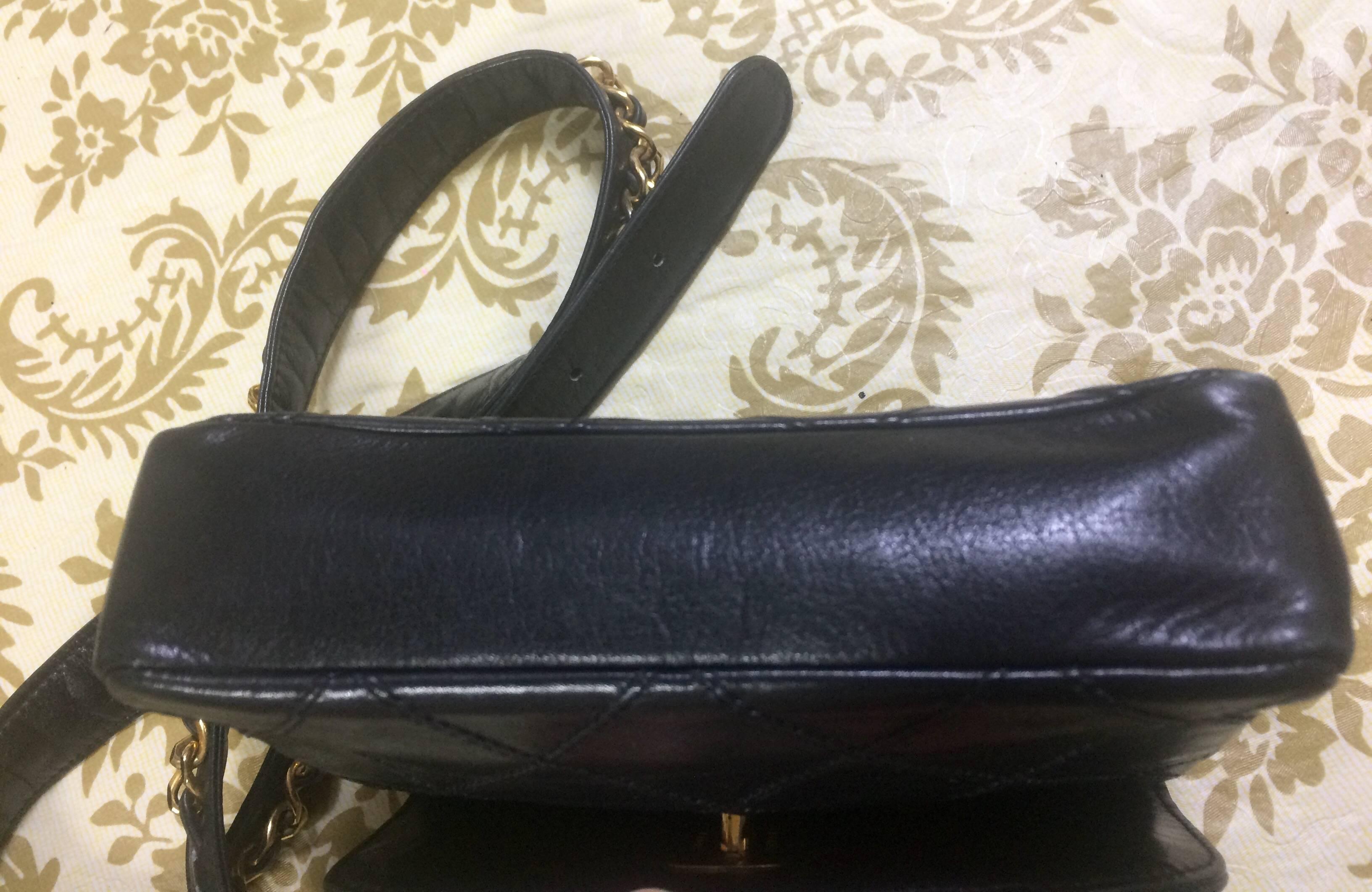 Women's Vintage CHANEL black leather 2.55 waist purse, fanny bag with golden chain belt.