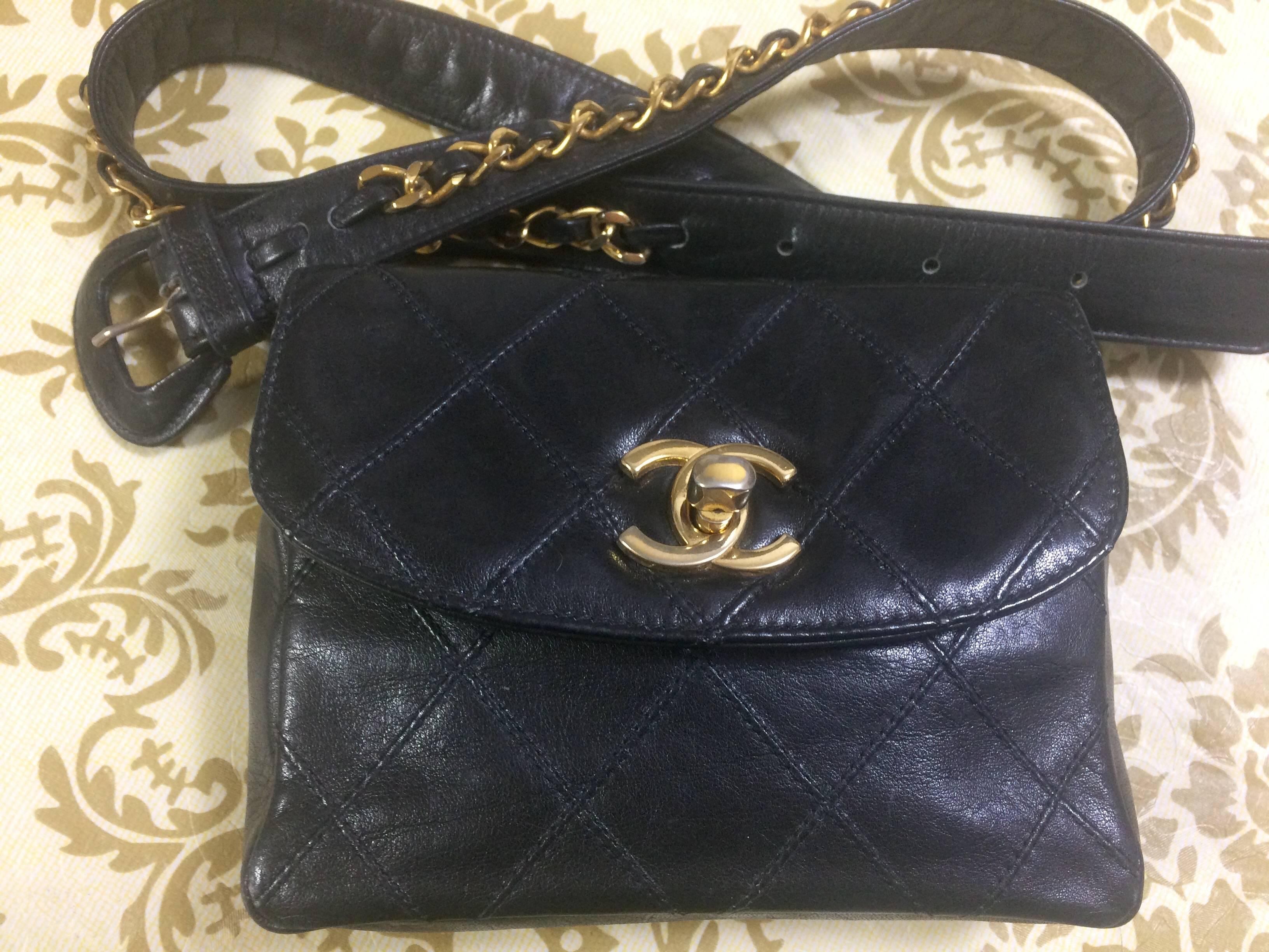 1980s. Vintage CHANEL black leather waist purse, fanny bag with golden chain belt and golden CC closure hock. 26