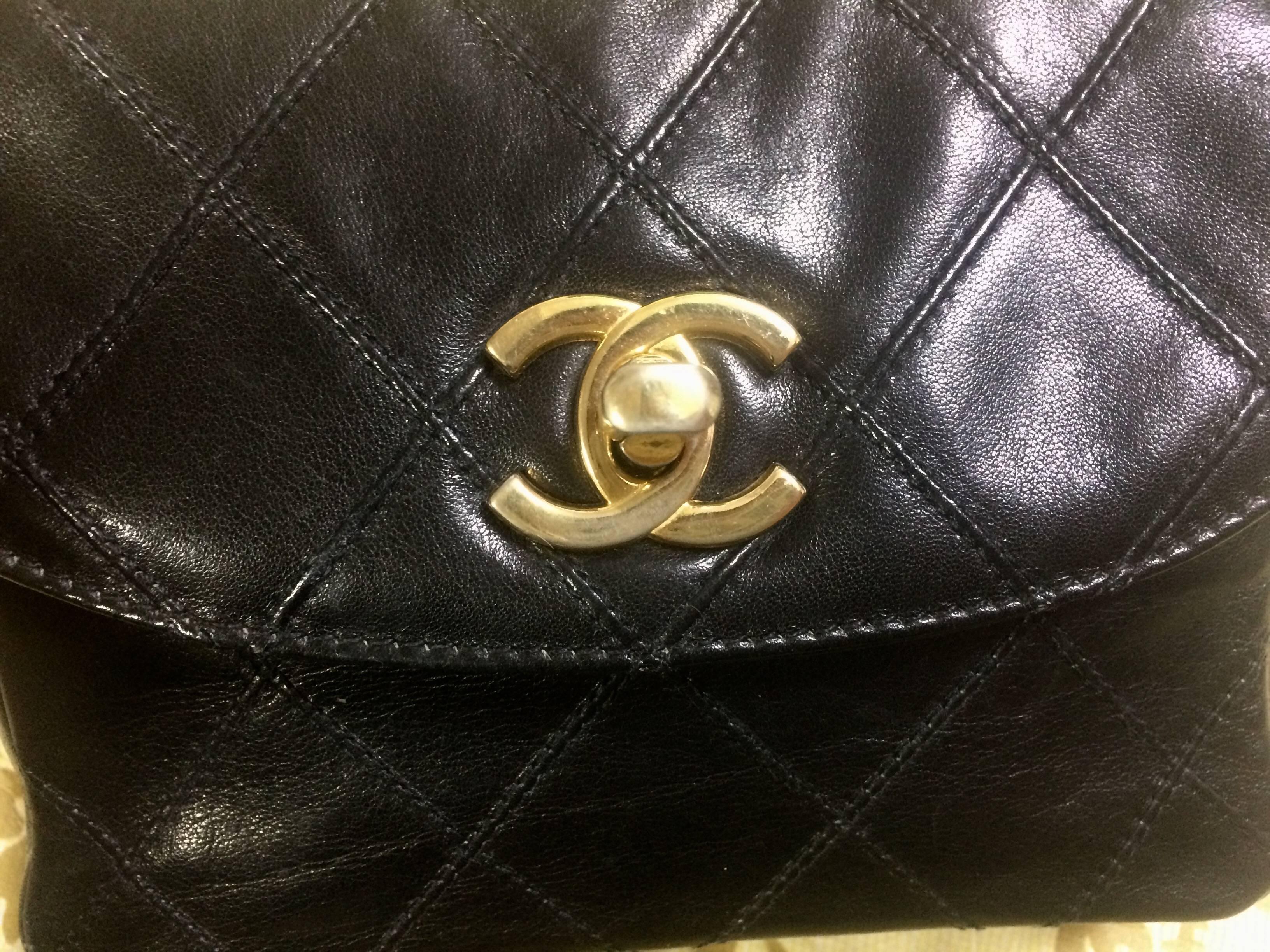 Black Vintage CHANEL black leather 2.55 waist purse, fanny bag with golden chain belt.