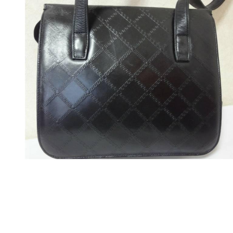Black Vintage Gianni Versace black leather tote bag with a tassel and sunburst motifs.