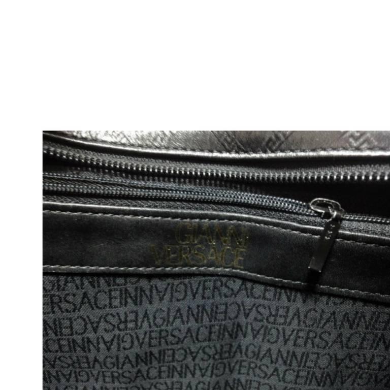 Vintage Gianni Versace black leather tote bag with a tassel and sunburst motifs. 2