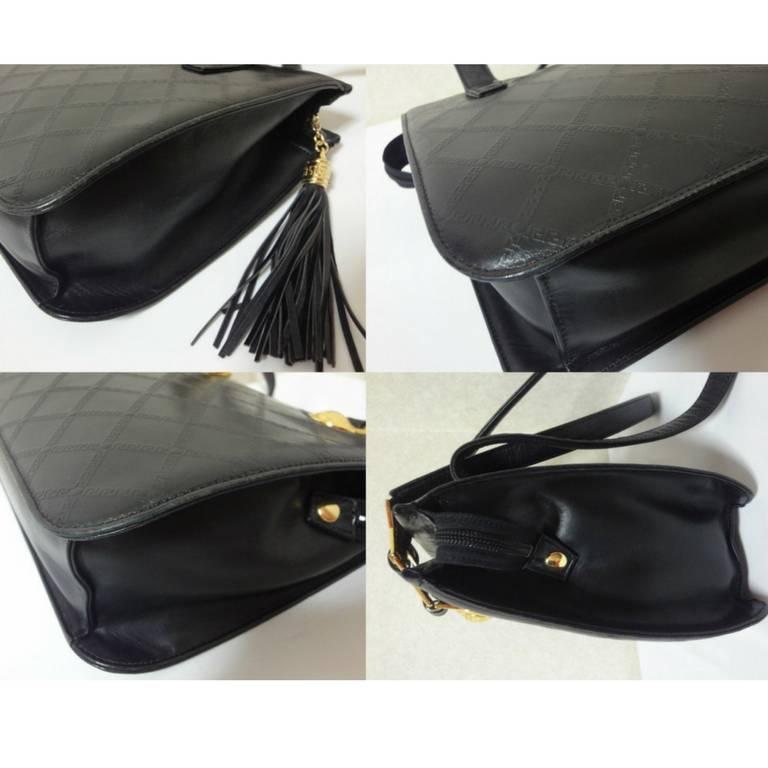 Vintage Gianni Versace black leather tote bag with a tassel and sunburst motifs. 1